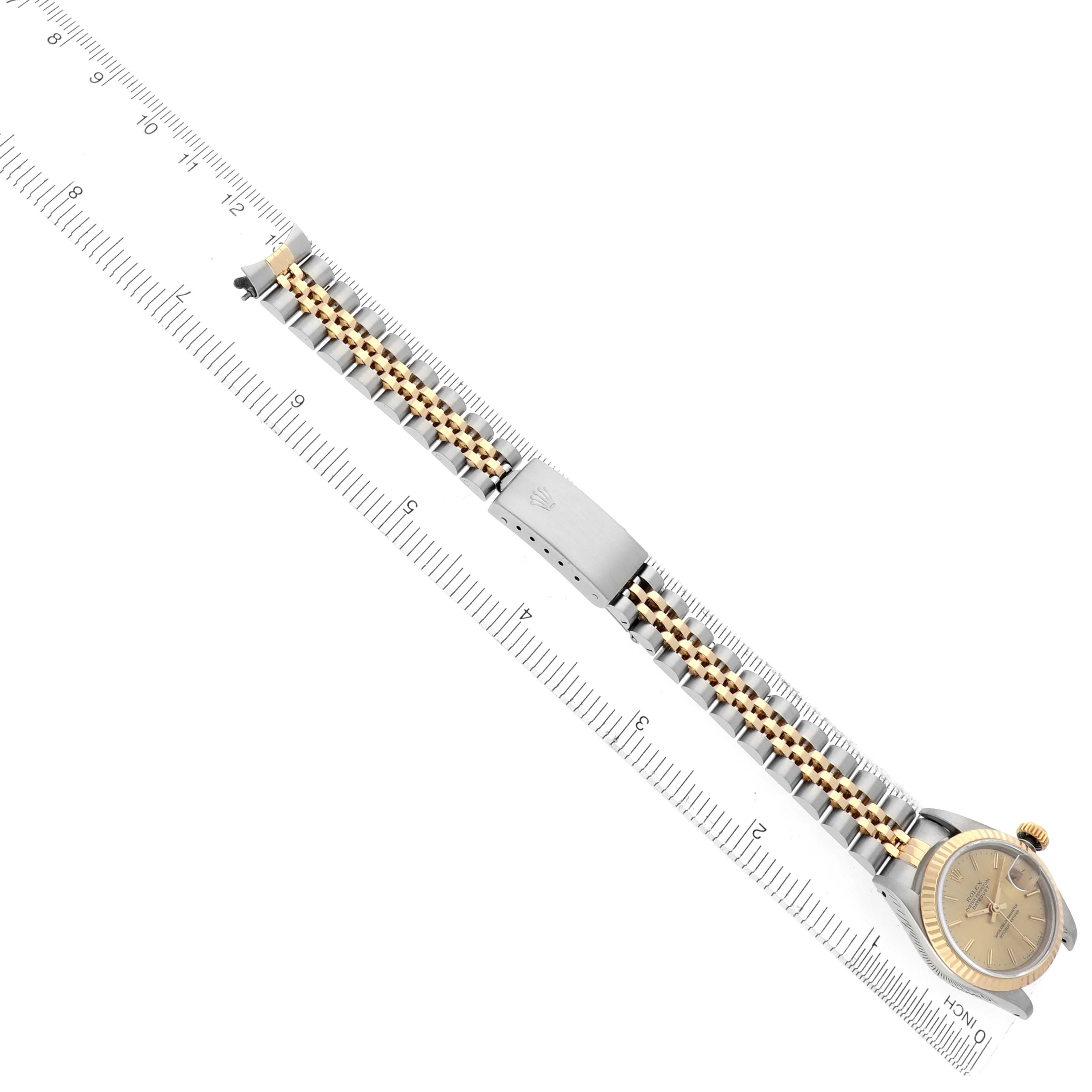 The Rolex Datejust 69173 Women
s Steel and Gold (two tone) Champagne Dial 69173 Women
s Steel and Gold (two tone) Champagne Dial watch is shown from the side, displaying the bracelet, clasp, and part of the face, with a measuring ruler for scale.