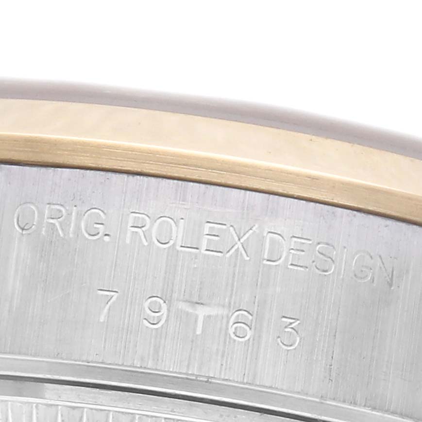 The image shows a close-up of the side engraving on a Rolex Datejust 79163 Women's Steel and Gold (two tone) Champagne Dial 79163 Women's Steel and Gold (two tone) Champagne Dial watch, focusing on the bezel and serial number area.