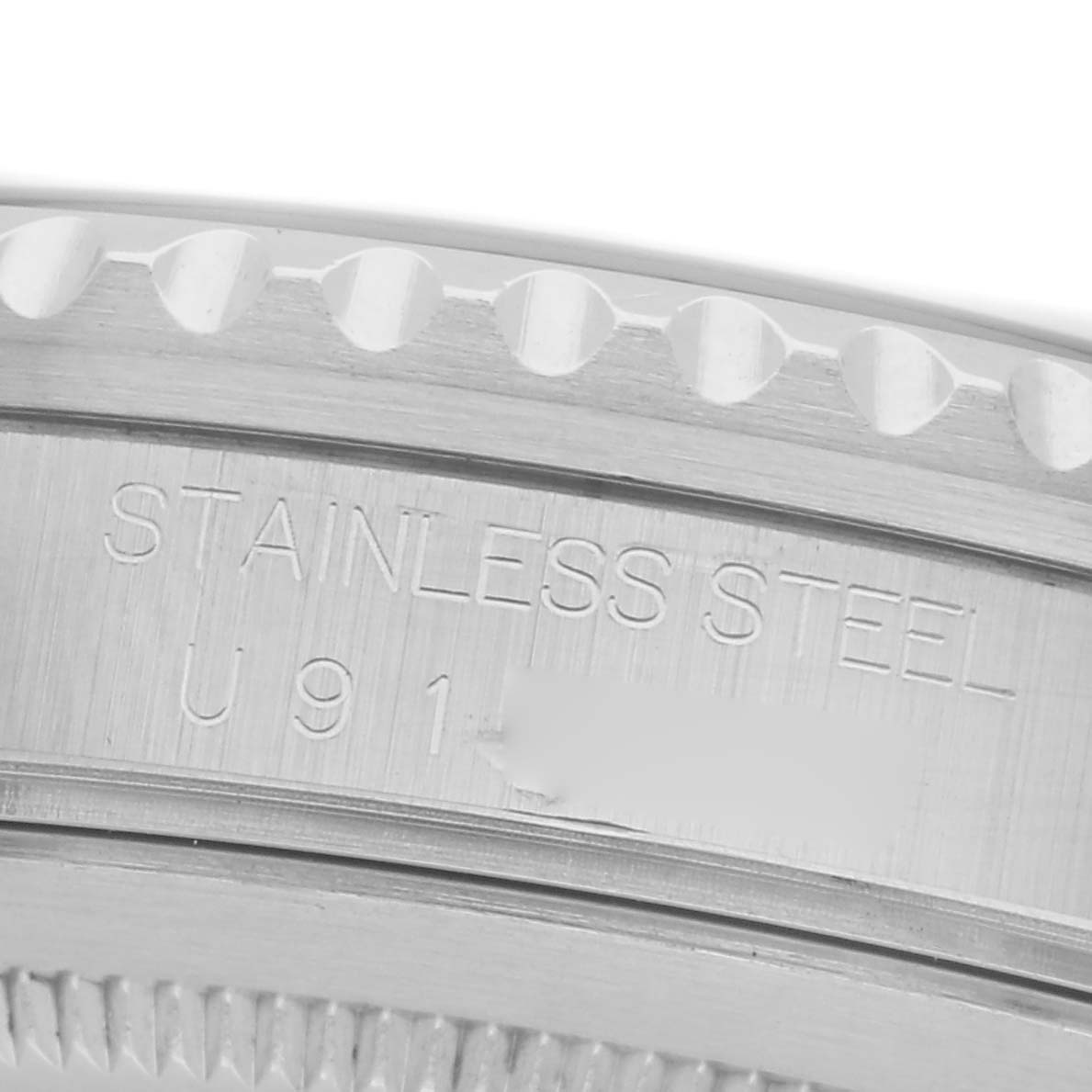 The image shows the edge of a Rolex GMT-Master 16700 Men
s Stainless Steel Black Dial 16700 Men
s Stainless Steel Black Dial watch, highlighting the stainless steel part with engraved text.