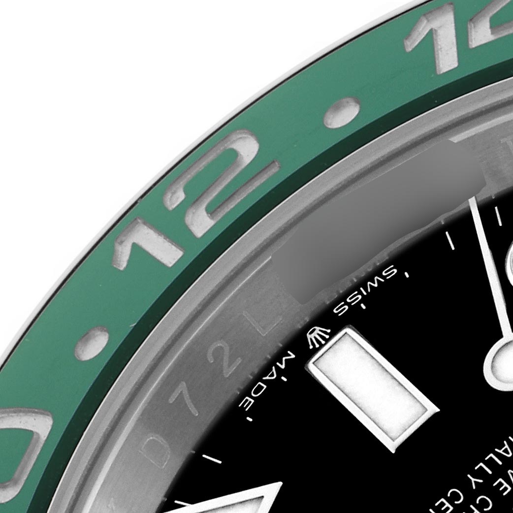 The image shows a close-up of a Rolex GMT-Master 126720VTNR Men
s Stainless Steel Black Dial 126720VTNR Men
s Stainless Steel Black Dial bezel and a portion of the dial with a focus on the 12 o
clock numeral.