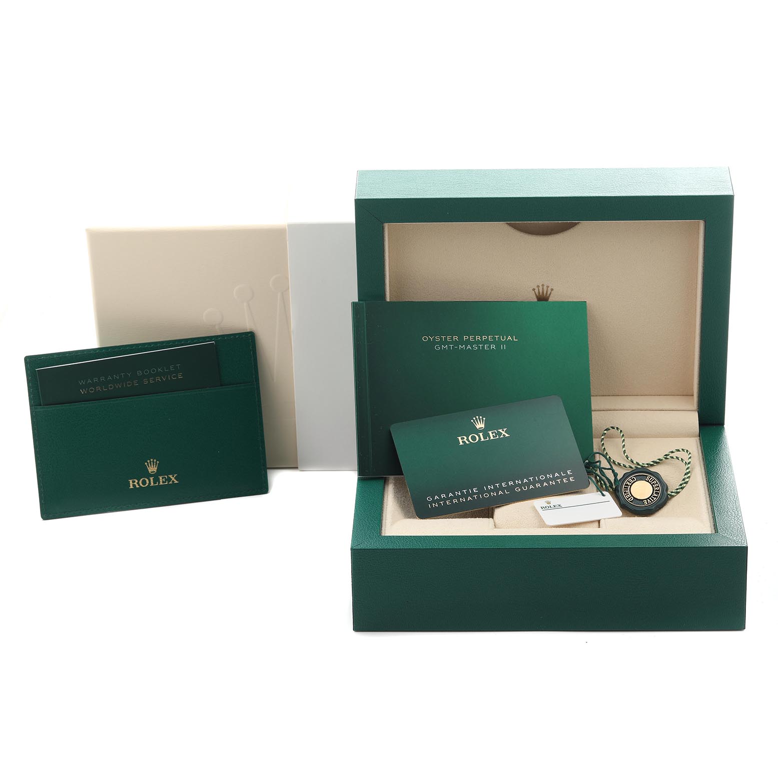 The image shows an open green Rolex box with documentation and a tag for the GMT-Master model, viewed from the front.
