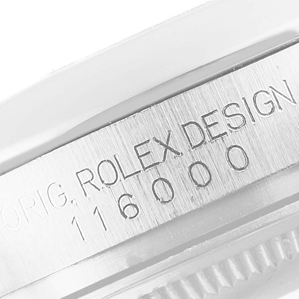 This close-up image shows the engraved details and model number on the case of a Rolex Oyster Perpetual 116000 Men's Stainless Steel Silver Dial 116000 Men's Stainless Steel Silver Dial watch.