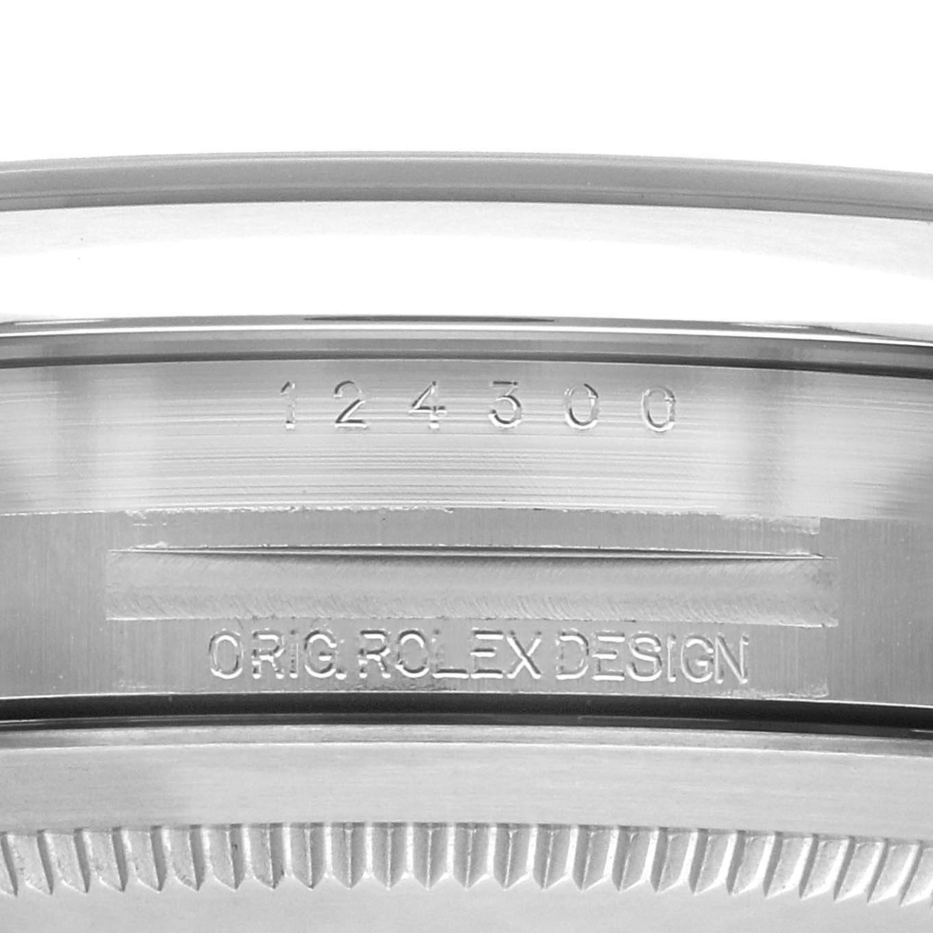 The image shows a close-up of the bezel side of a Rolex Oyster Perpetual 124300 Men
s Stainless Steel Black Dial 124300 Men
s Stainless Steel Black Dial, highlighting the model number and "Orig. Rolex Design" engraving.