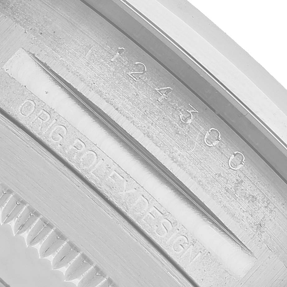 The image shows a close-up of the inner casing of a Rolex Oyster Perpetual 124300 Men's Stainless Steel Blue Dial watch, highlighting the serial number and "ORIG ROLEX DESIGN" engraving.