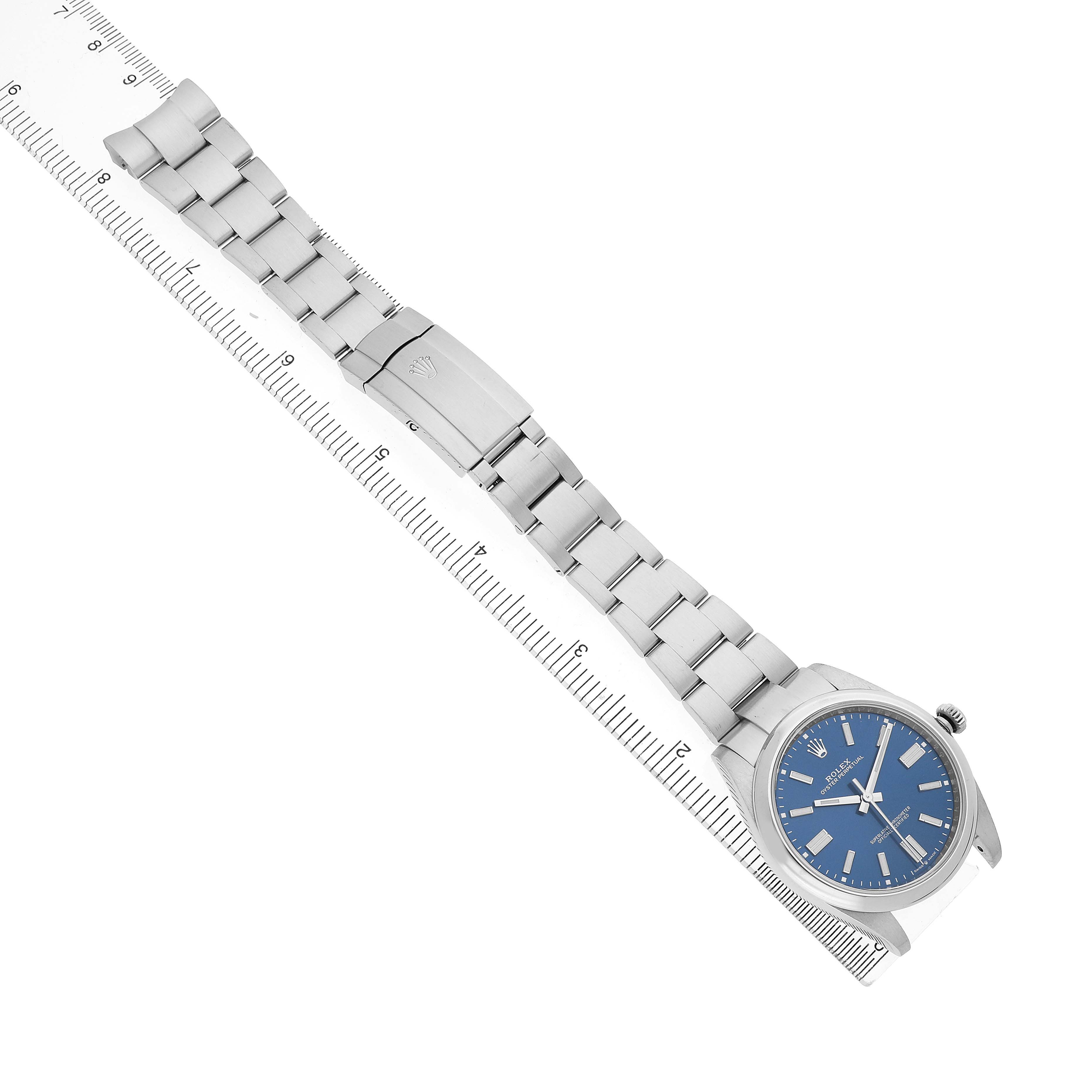 The Rolex Oyster Perpetual 124300 Men's Stainless Steel Blue Dial watch is displayed slightly angled, showing the bracelet, clasp, and blue dial.