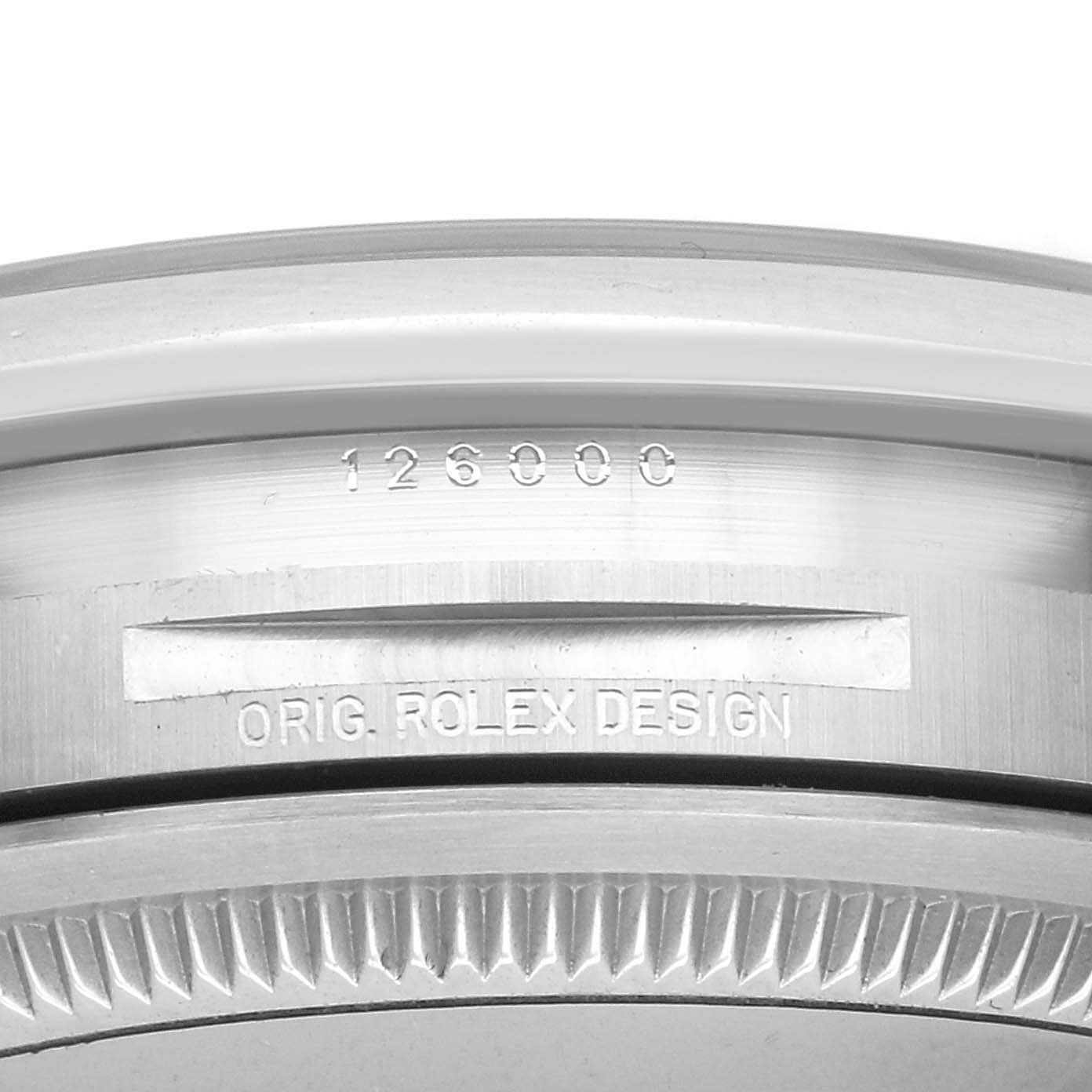 The image shows a close-up of the case edge and bezel of a Rolex Oyster Perpetual 126000 Men
s Stainless Steel Pink Dial 126000 Men
s Stainless Steel Pink Dial, highlighting the engraved serial number and "ORIG. ROLEX DESIGN."