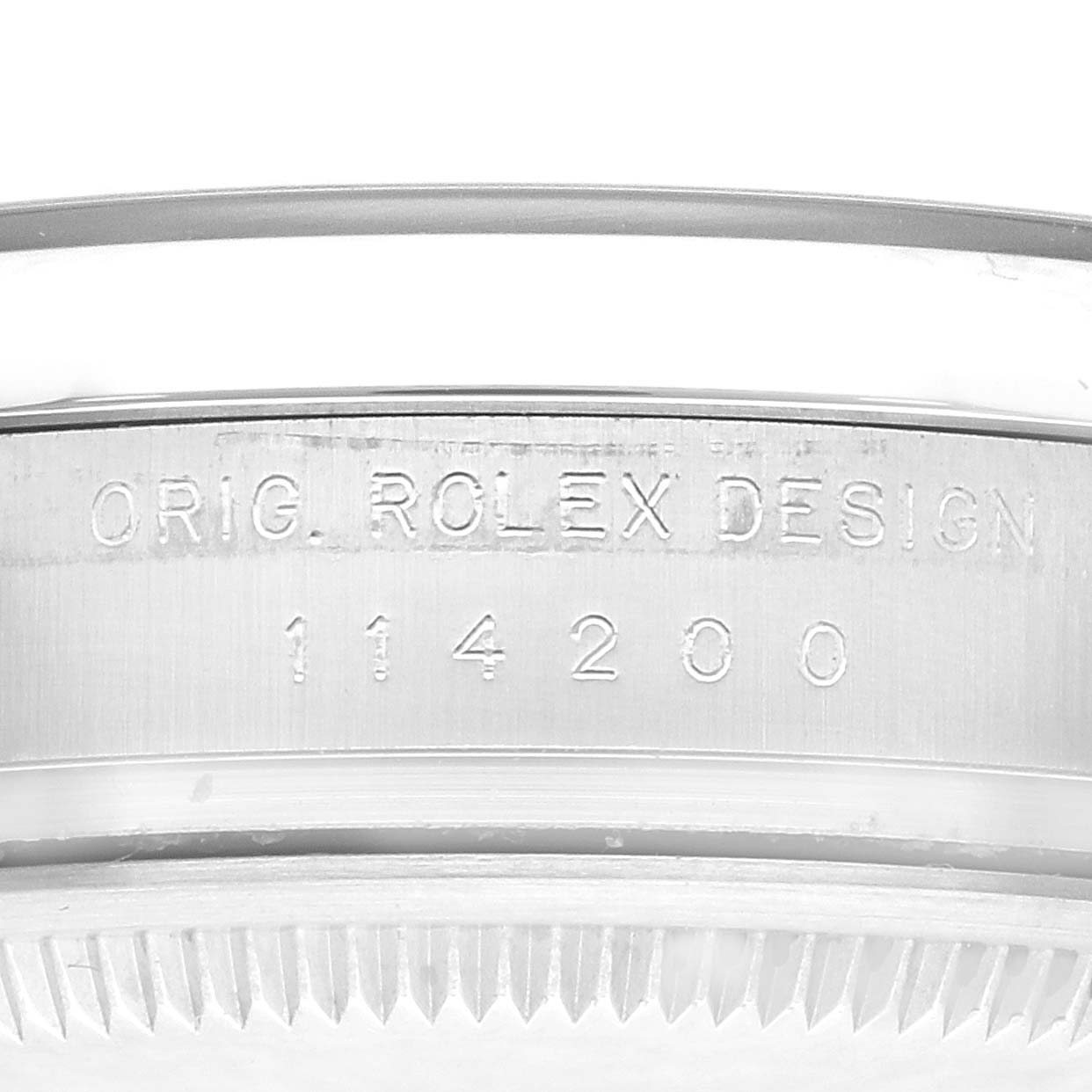 The image shows the side of the casing of the Rolex Oyster Perpetual 114200 Men's Stainless Steel Green Dial 114200 Men's Stainless Steel Green Dial watch, featuring the engraved design and model number.