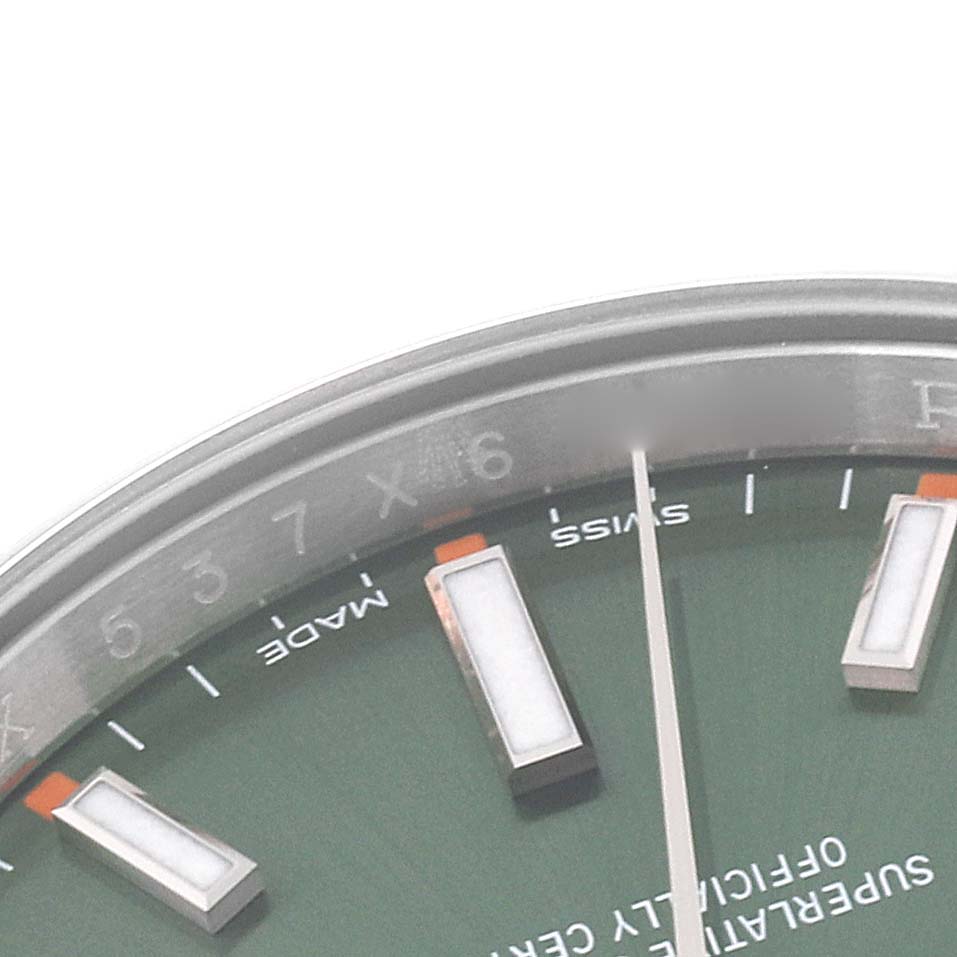 This close-up image displays a partial view of the dial and markers of a Rolex Oyster Perpetual 114200 Men's Stainless Steel Green Dial 114200 Men's Stainless Steel Green Dial watch, focused on the 5-7 hour markers.