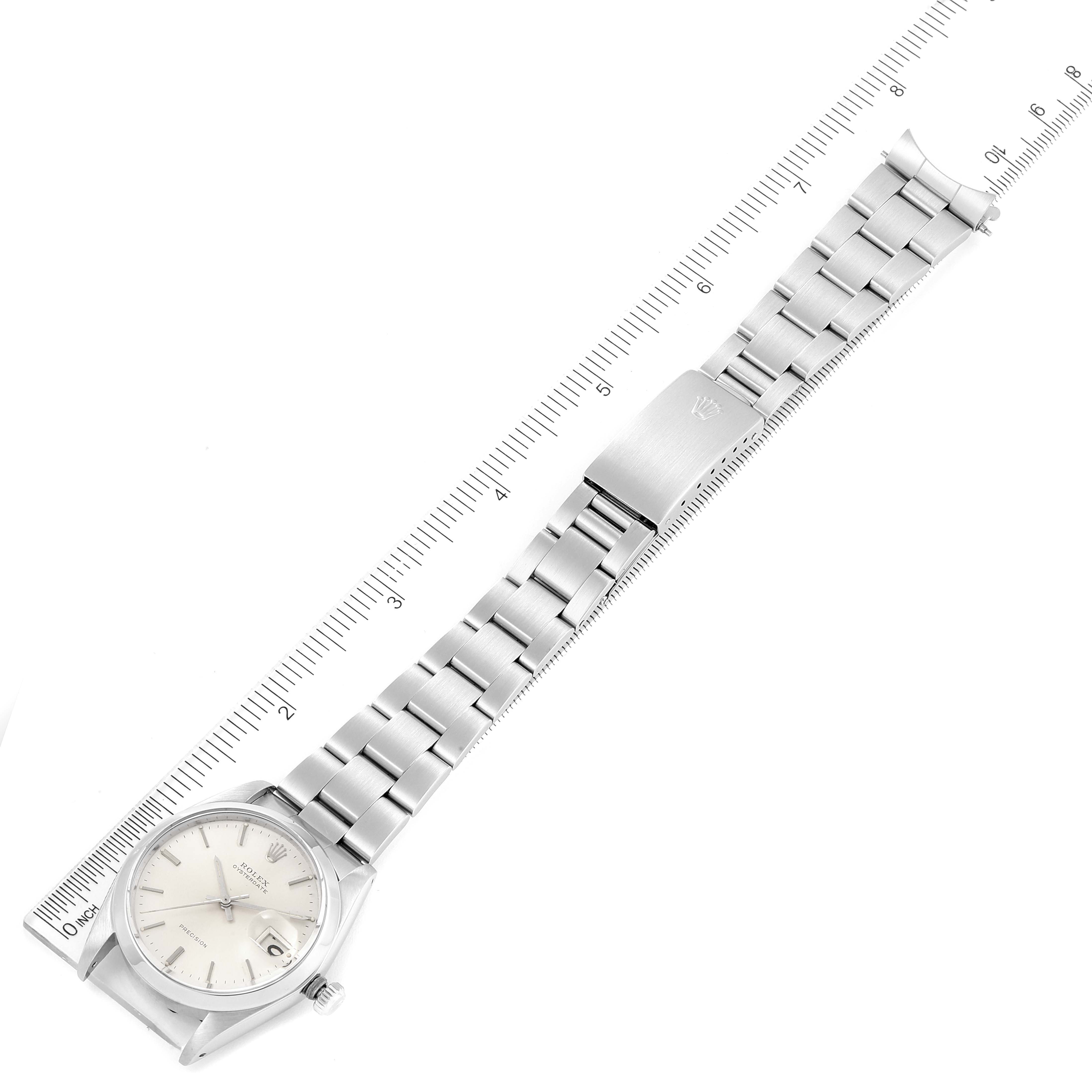 The Rolex Vintage Collection 6694 Men's Stainless Steel Silver Dial 6694 Men's Stainless Steel Silver Dial watch is displayed flat, showing its face, strap, and clasp alongside a ruler for scale.