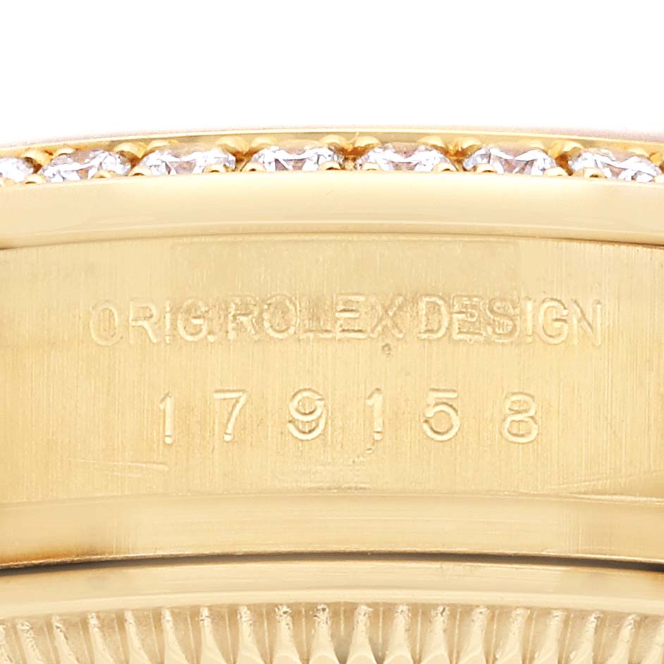 This close-up shows the model number and design inscription of a Rolex President 179158 Women
s Yellow Gold Champagne Dial 179158 Women
s Yellow Gold Champagne Dial watch, along with part of the diamond bezel.