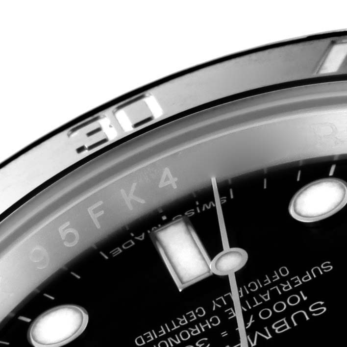 The image shows a close-up angle of a Rolex Submariner 114060 Men
s Stainless Steel Black Dial 114060 Men
s Stainless Steel Black Dial watch face, focusing on the bezel, indices, and part of the text.