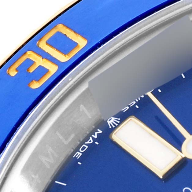 A close-up of a Rolex Submariner 126613LB Men's Steel and Gold (two tone) Blue Dial 126613LB Men's Steel and Gold (two tone) Blue Dial showing part of the blue bezel with a gold "30" and partial view of the watch face.