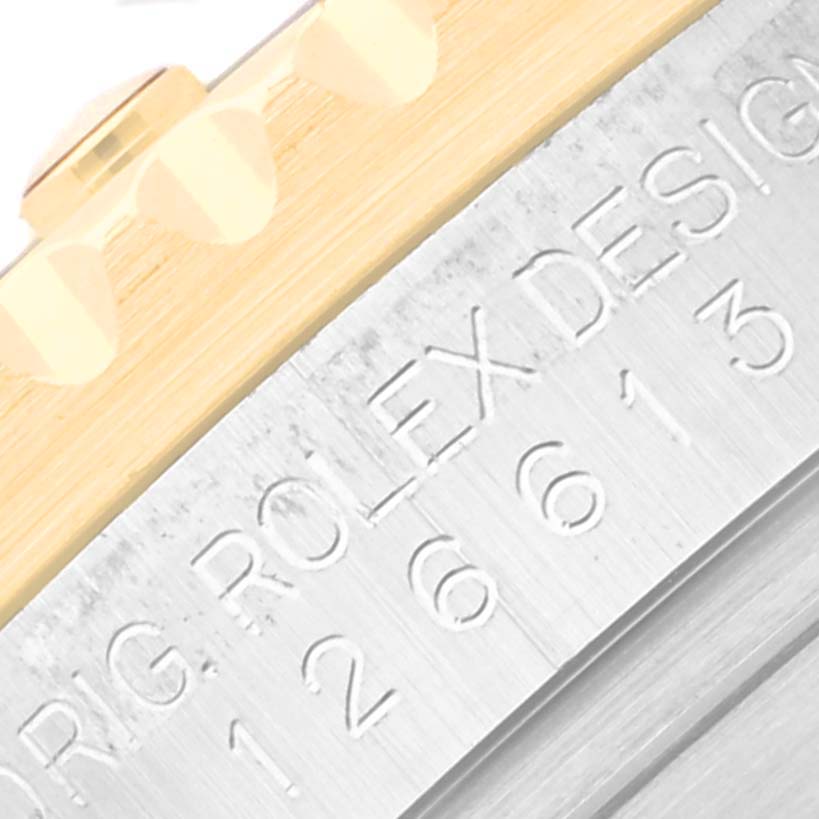 This image shows a close-up angle of the Rolex Submariner 126613LB Men's Steel and Gold (two tone) Blue Dial 126613LB Men's Steel and Gold (two tone) Blue Dial's case, featuring the Rolex design engraving and part of the bezel teeth.