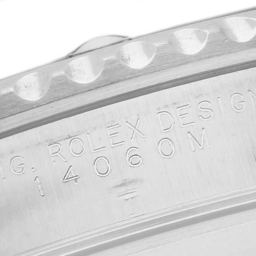 The image shows a close-up of the side engraving on the Rolex Submariner 14060M Men
s Stainless Steel Black Dial 14060M Men
s Stainless Steel Black Dial
s case, including part of the bezel and the engraved model number.