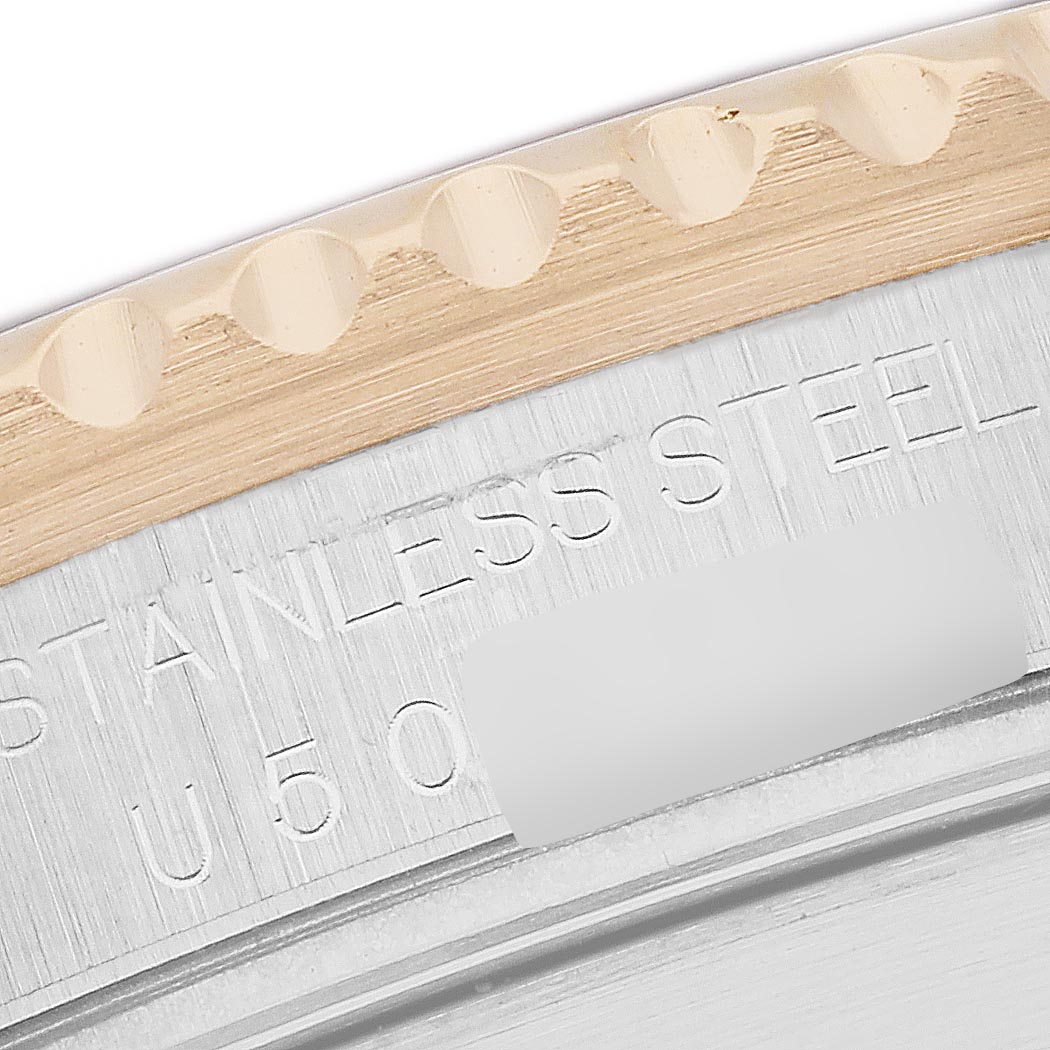 The image shows a close-up of the Submariner model by Rolex, highlighting the bezel and engraved markings on the case.