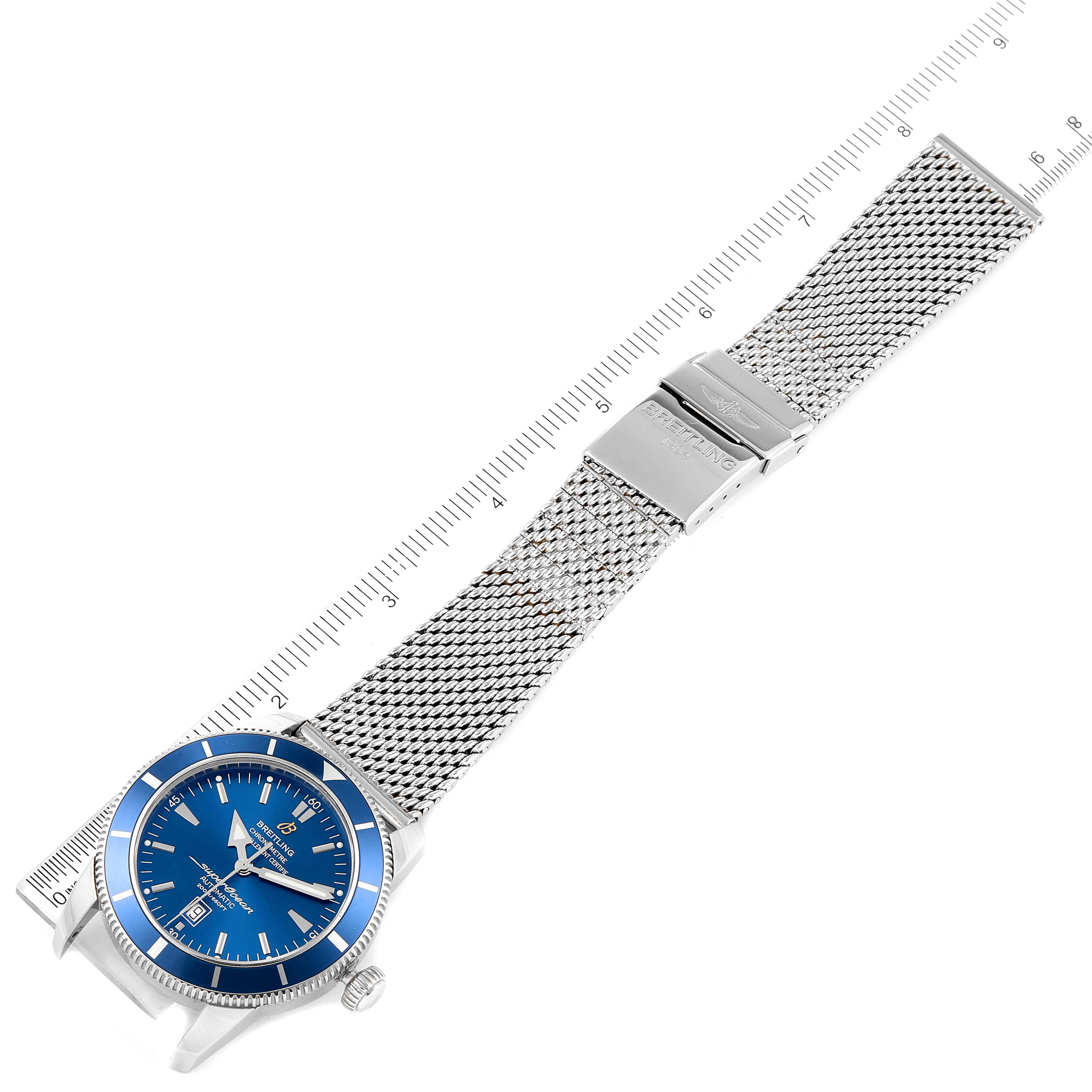 The image shows a Breitling Superocean A17320 Men's Stainless Steel Blue Dial A17320 Men's Stainless Steel Blue Dial watch laid flat with a blue dial and a stainless steel mesh bracelet, alongside a ruler for size reference.