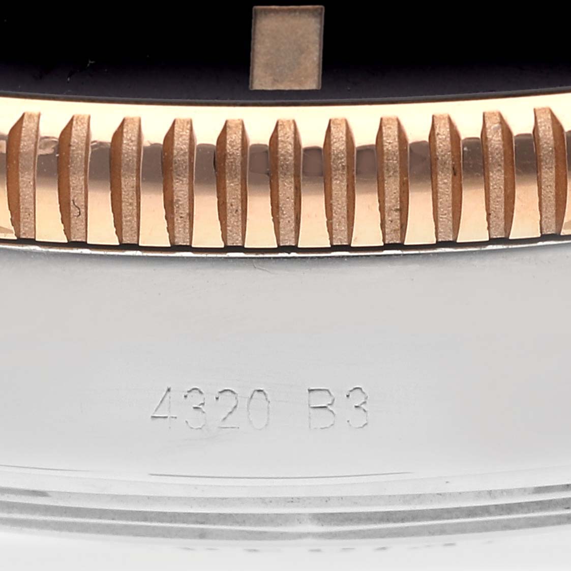 This close-up image shows the engraved casing and part of the bezel of a Breitling Superocean UB2030121B1A1 Men's Steel and Gold (two tone) Black Dial UB2030121B1A1 Men's Steel and Gold (two tone) Black Dial model watch.