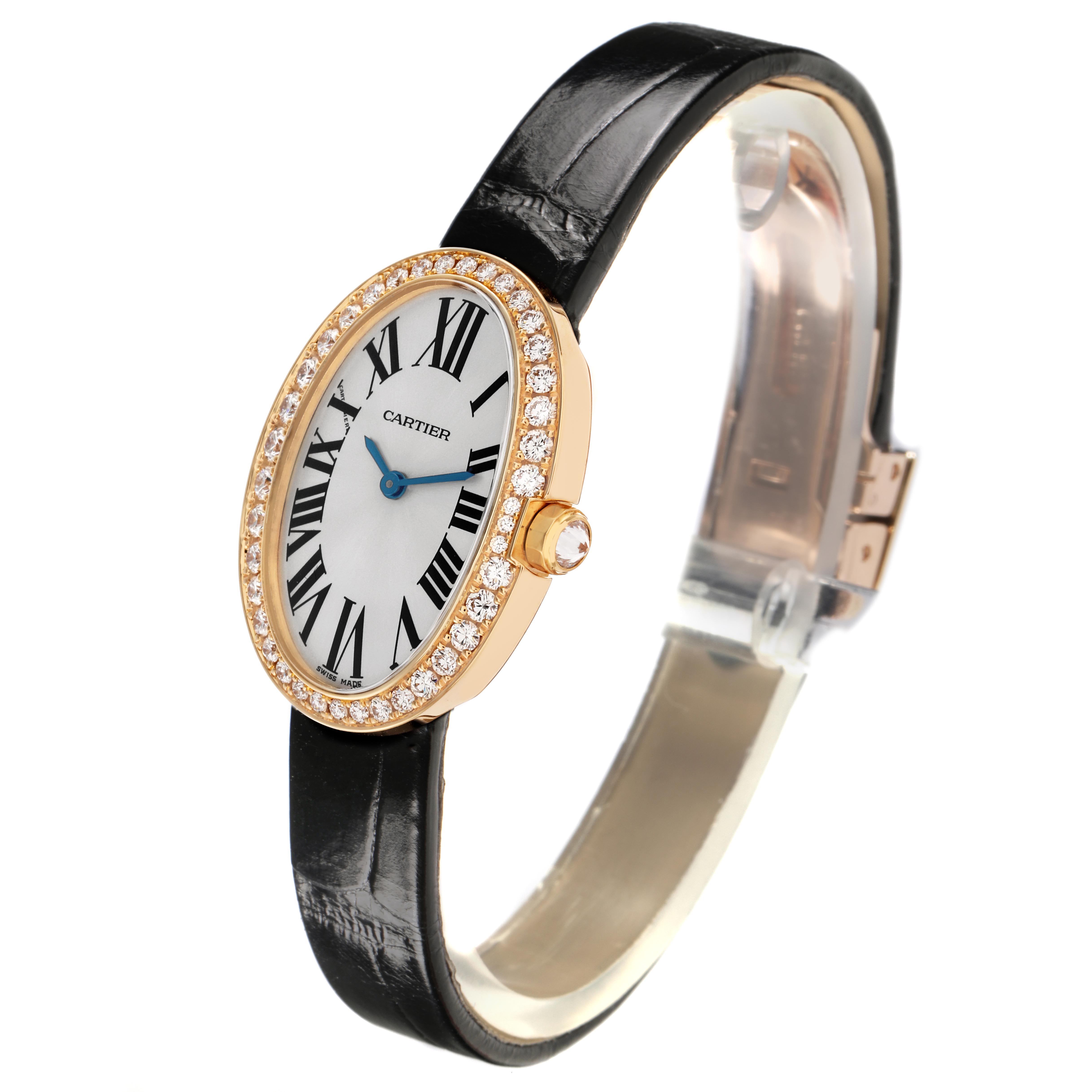 The Cartier Baignoire WB520020 Women
s Yellow Gold Silver Dial WB520020 Women
s Yellow Gold Silver Dial watch is shown at a three-quarter angle, displaying the oval face, diamond bezel, and black strap.