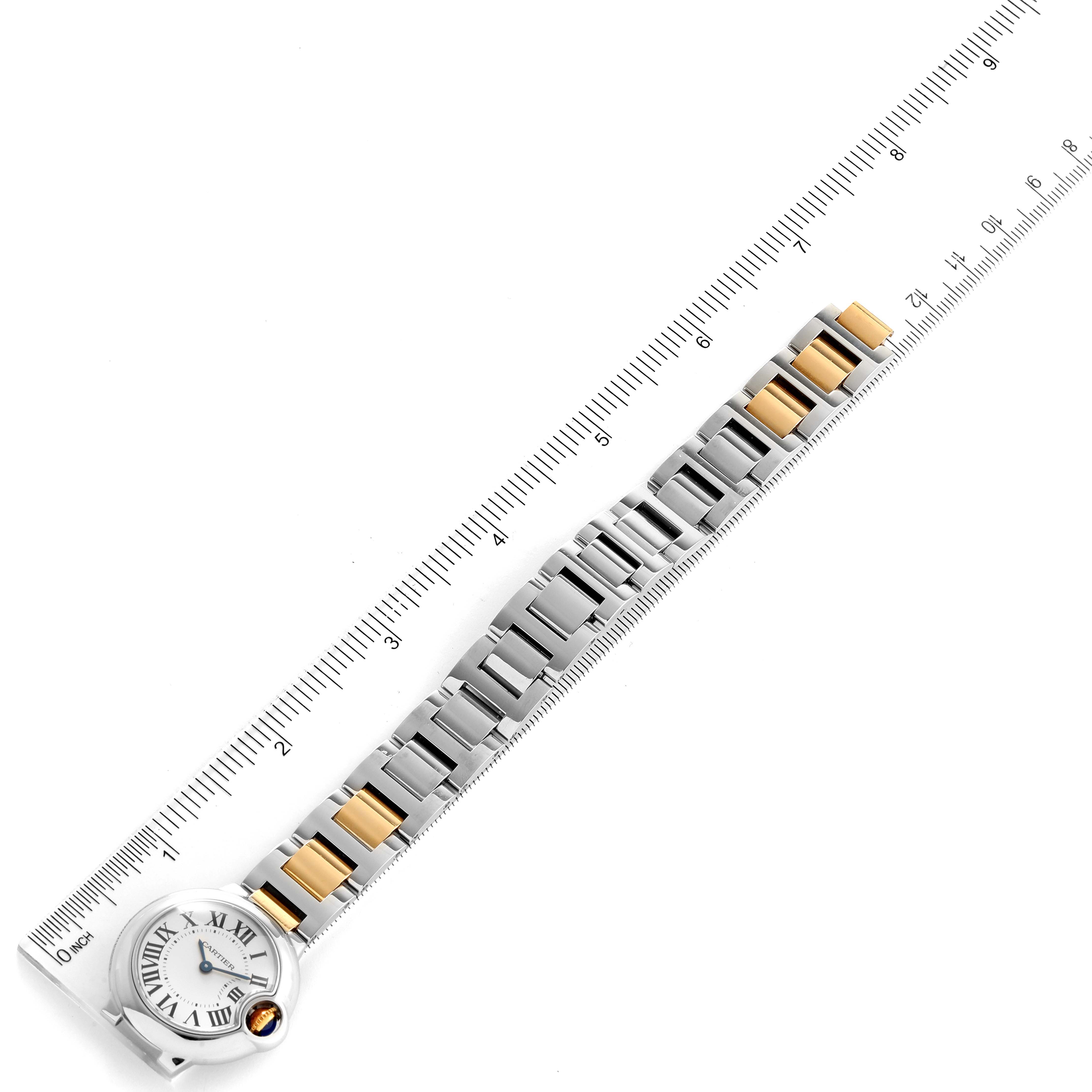 This image shows a flat-lay view of a Cartier Ballon Bleu W69007Z3 Women
s Steel and Gold (two tone) Silver Dial W69007Z3 Women
s Steel and Gold (two tone) Silver Dial watch, displaying its face and two-tone metal bracelet alongside a ruler.