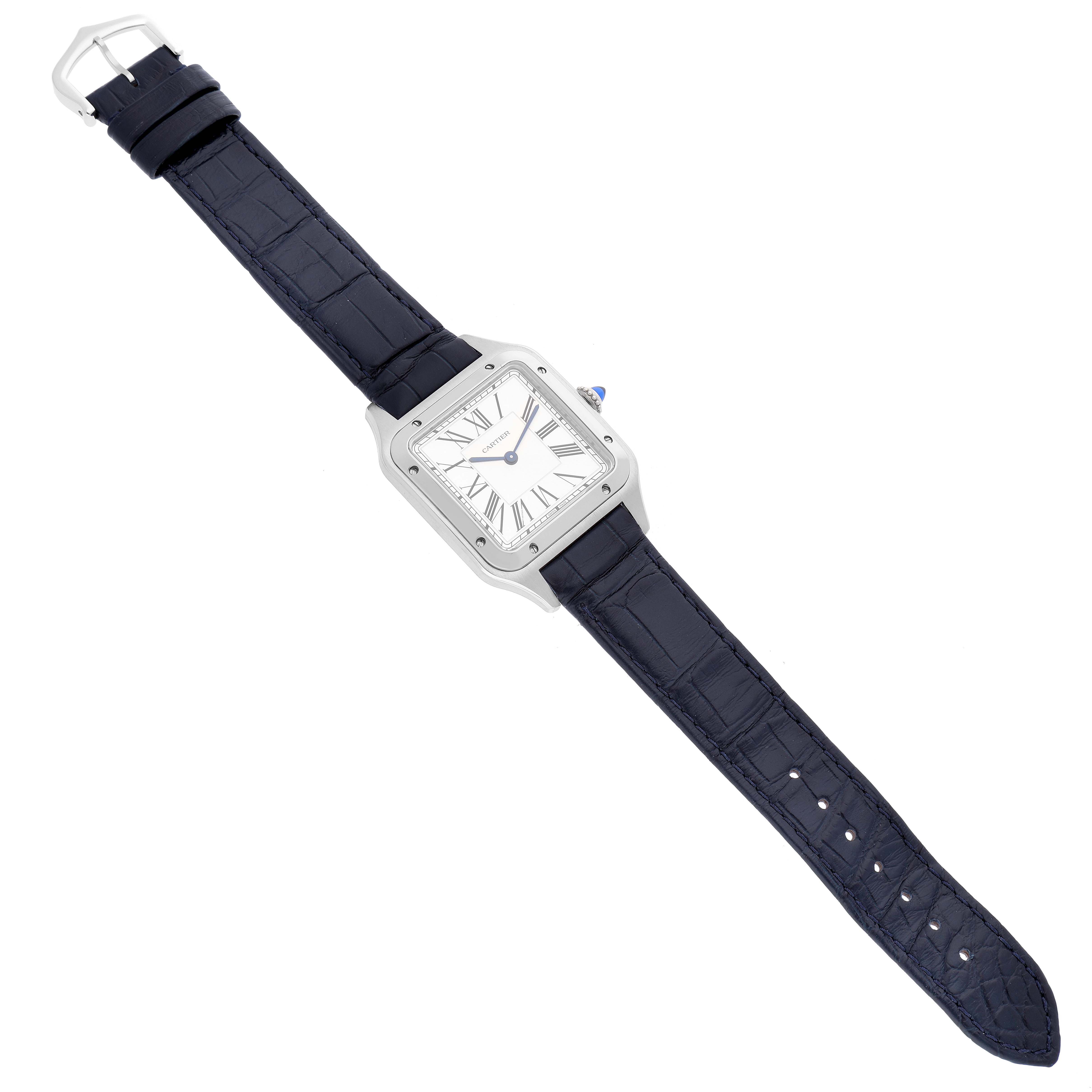 The image shows a Cartier Santos Dumont WSSA0022 Men's Stainless Steel Silver Dial WSSA0022 Men's Stainless Steel Silver Dial watch from a top-down angle, highlighting its face, blue strap, and buckle.