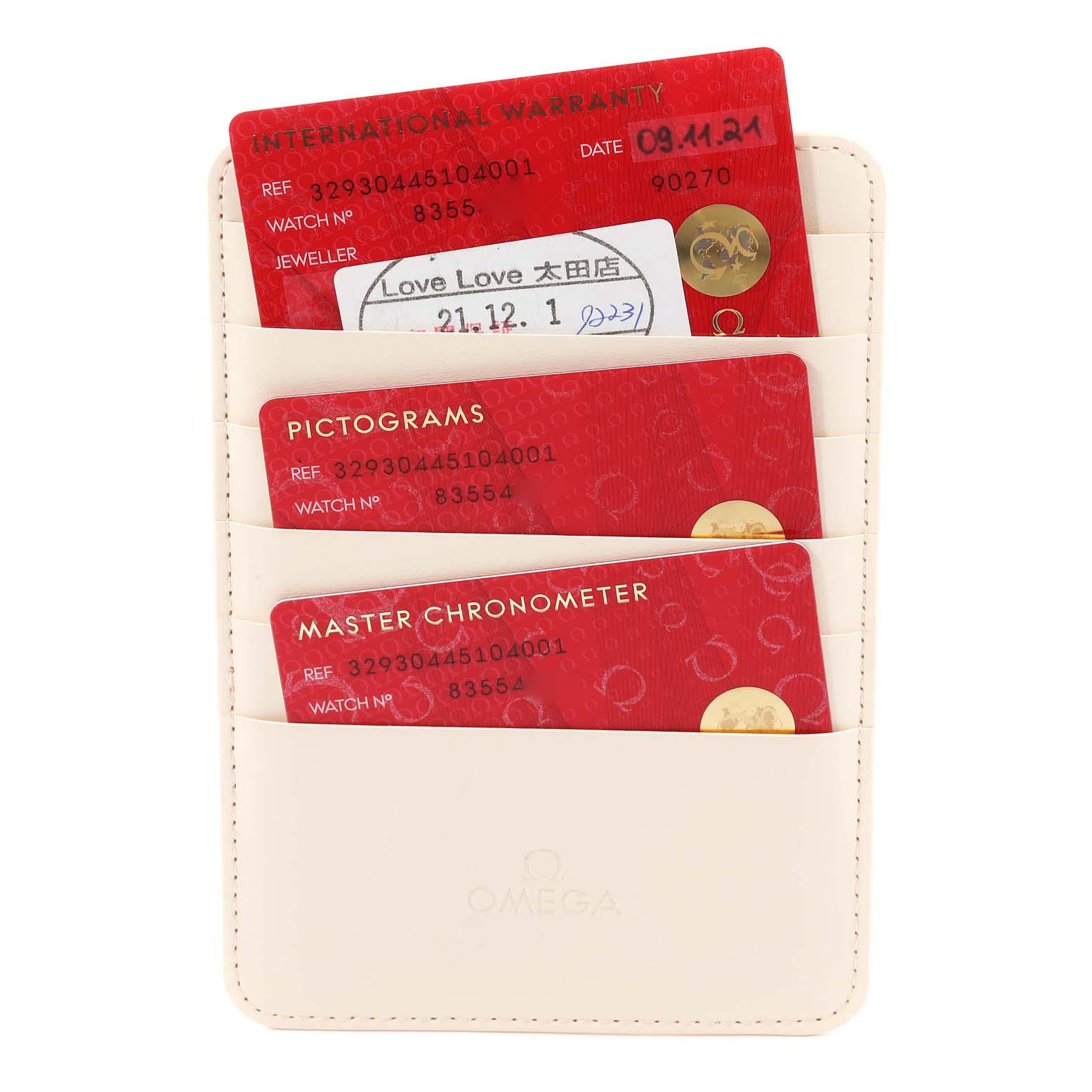 This image shows the warranty and certification cards for the Omega Speedmaster 329.30.44.51.04.001 Men
s Stainless Steel White Dial 329.30.44.51.04.001 Men
s Stainless Steel White Dial watch, placed in a beige cardholder.