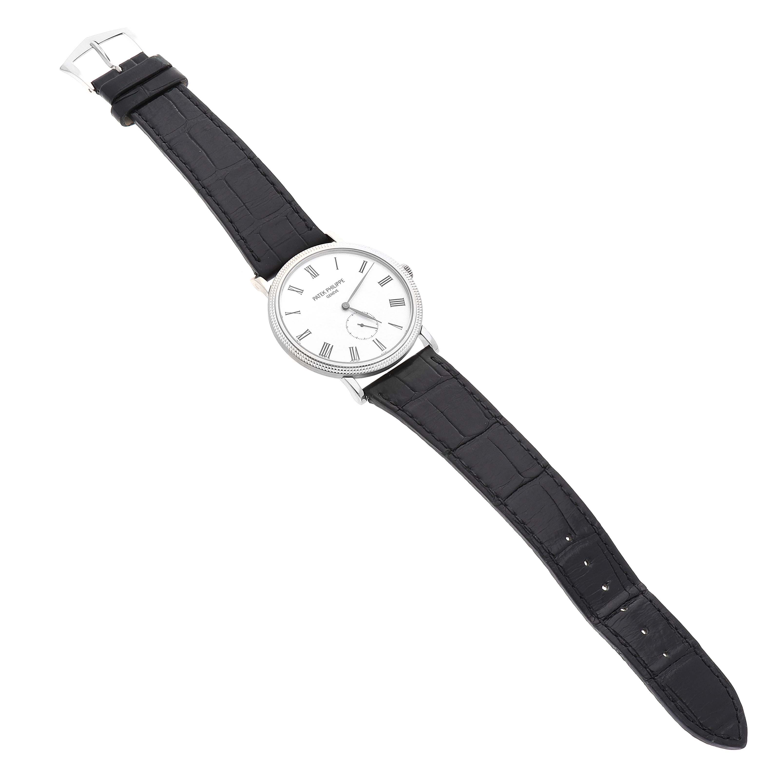 The Patek Philippe Calatrava 5119G-001 Men
s White Gold White Dial 5119G-001 Men
s White Gold White Dial watch is shown from a top-down angle, displaying its face and black leather strap.