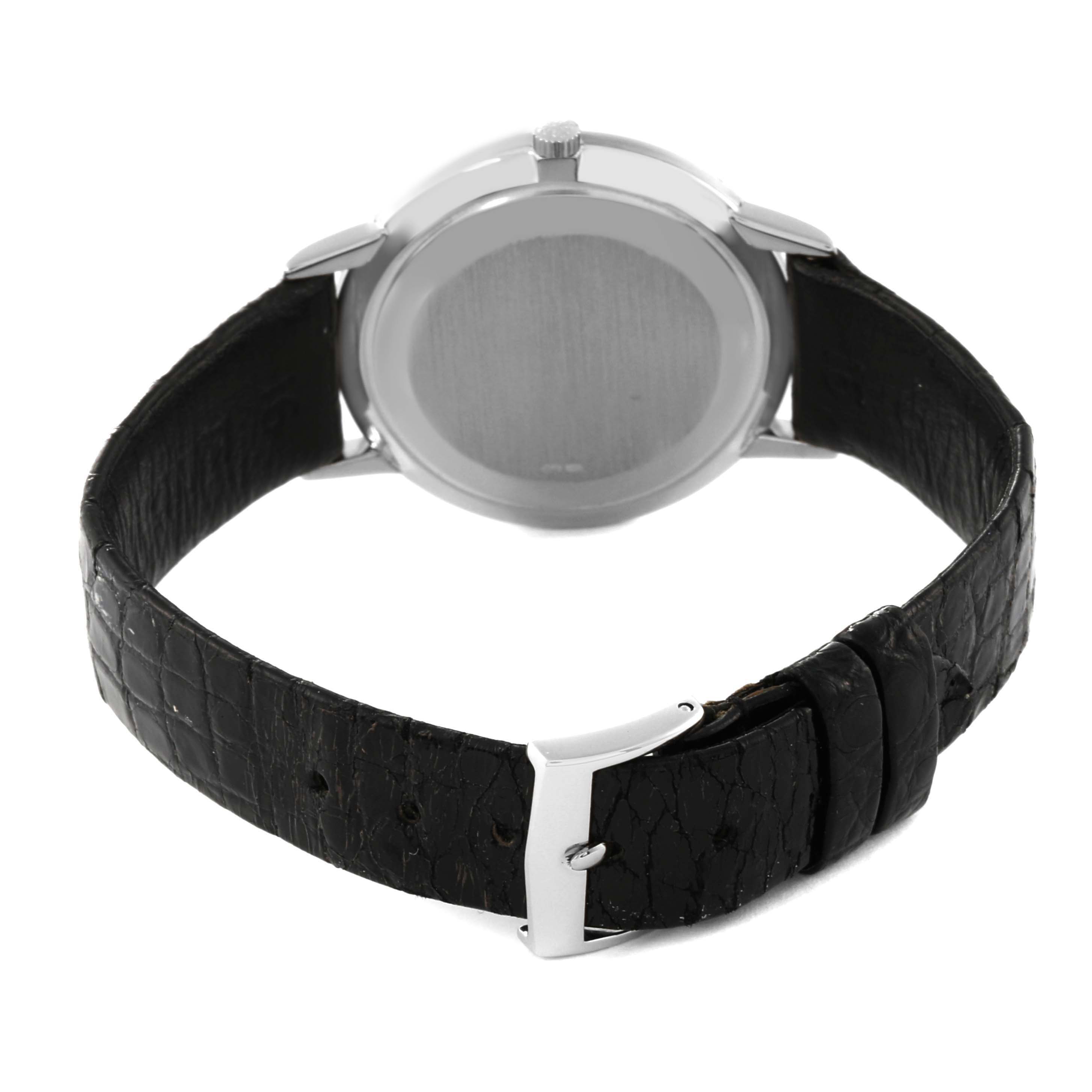 The image shows the back view of a Patek Philippe Calatrava 3893G Men
s White Gold White Dial 3893G Men
s White Gold White Dial watch with a black leather strap and a silver buckle.