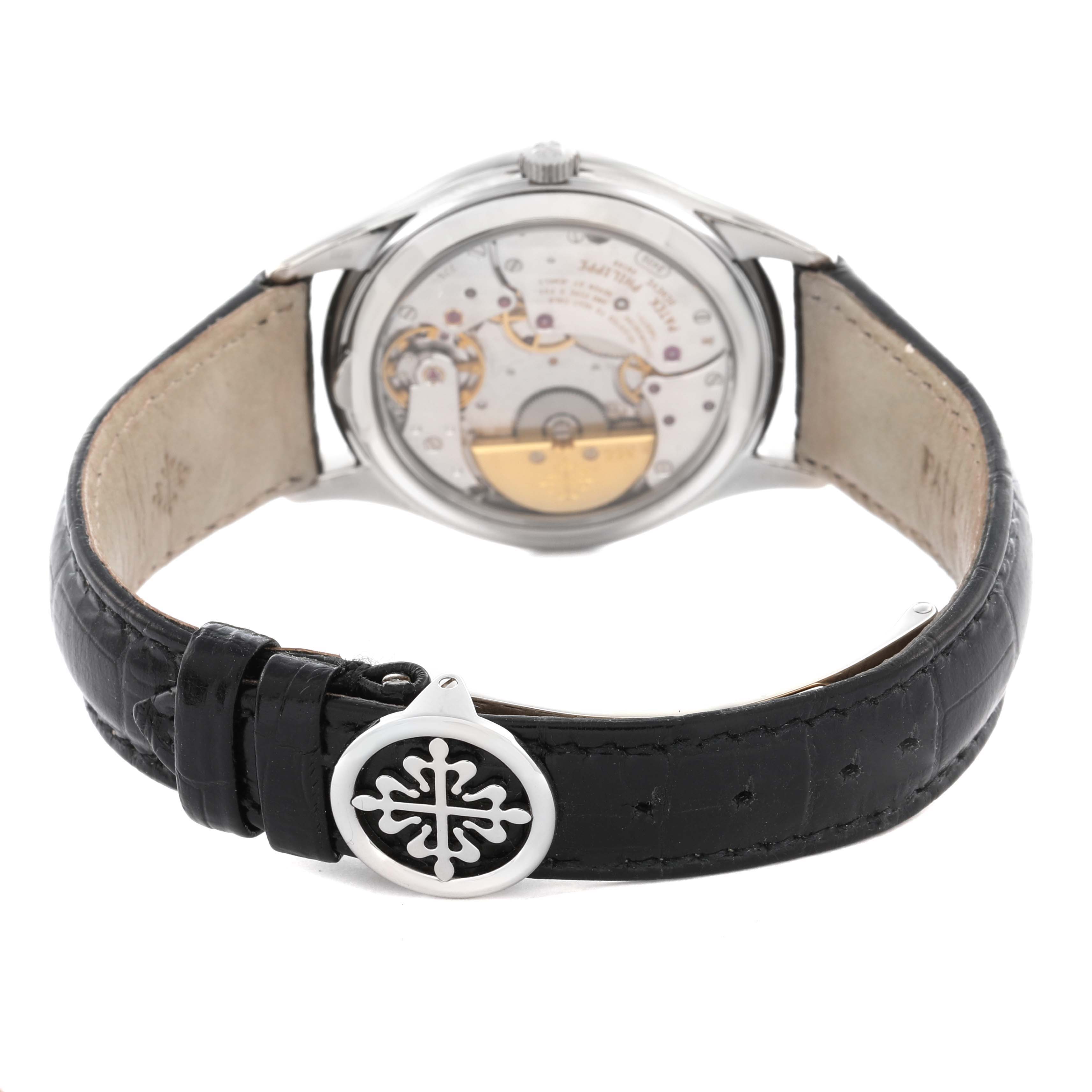 The Patek Philippe Complications 5038G Men
s White Gold Black Dial 5038G Men
s White Gold Black Dial watch is shown from the back, highlighting its movement and leather strap with a logo clasp.