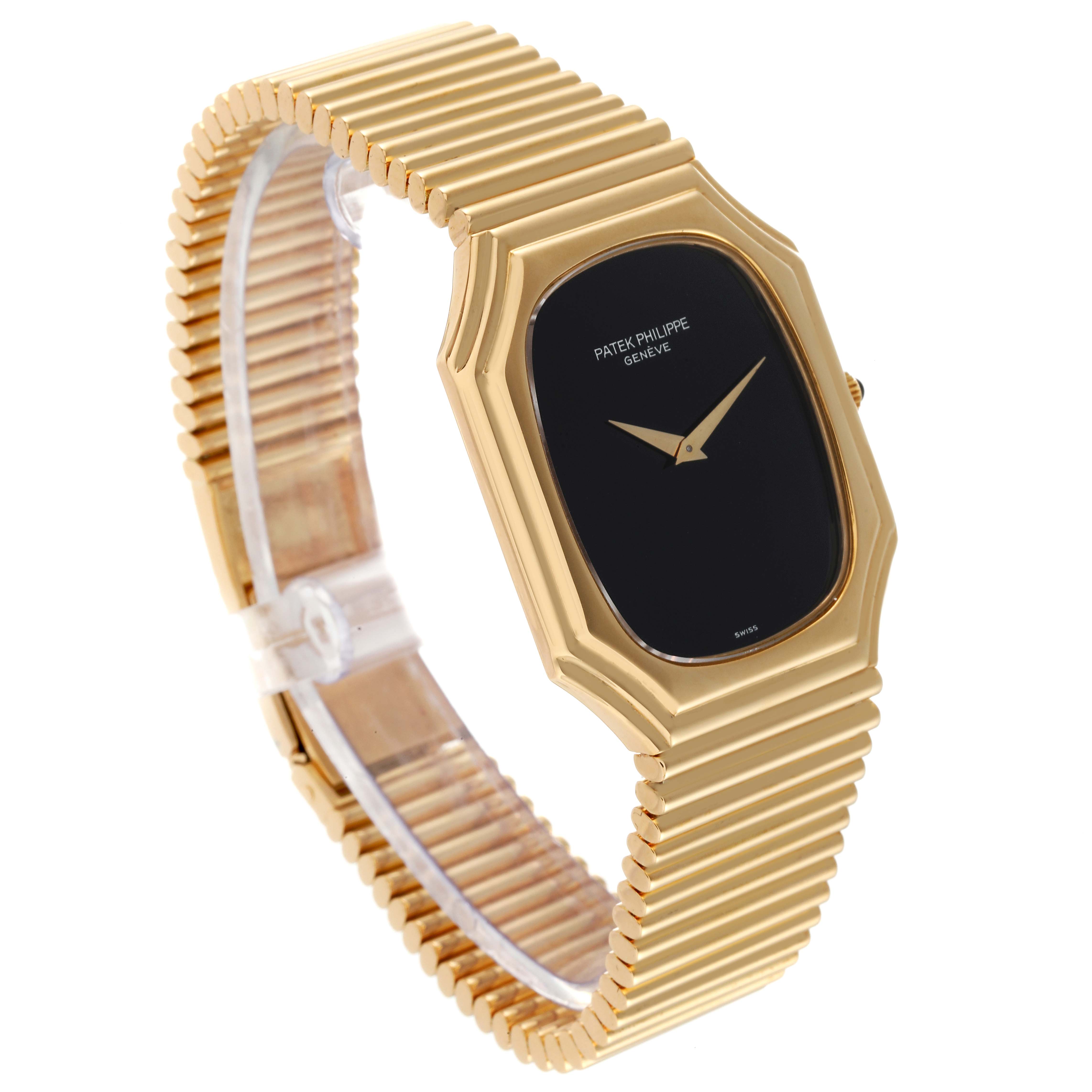 The image shows a side-angle view of a Vintage Patek Philippe watch, displaying the black dial, gold case, and gold bracelet.