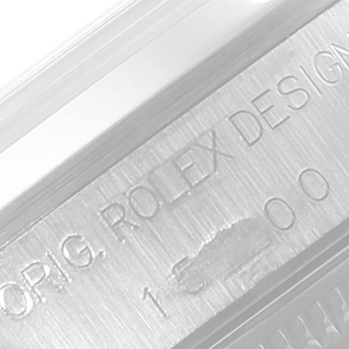 This image shows a close-up of the casing with "ORIG. ROLEX DESIGN" engraving and part of the serial number for a Rolex Date 15200 Men's Stainless Steel Blue Dial 15200 Men's Stainless Steel Blue Dial model watch.