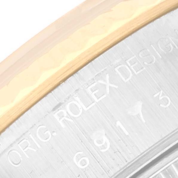 This close-up view of a Rolex Datejust 69173 Women's Steel and Gold (two tone) Black Dial 69173 Women's Steel and Gold (two tone) Black Dial watch shows part of the bezel and the inscribed casing.