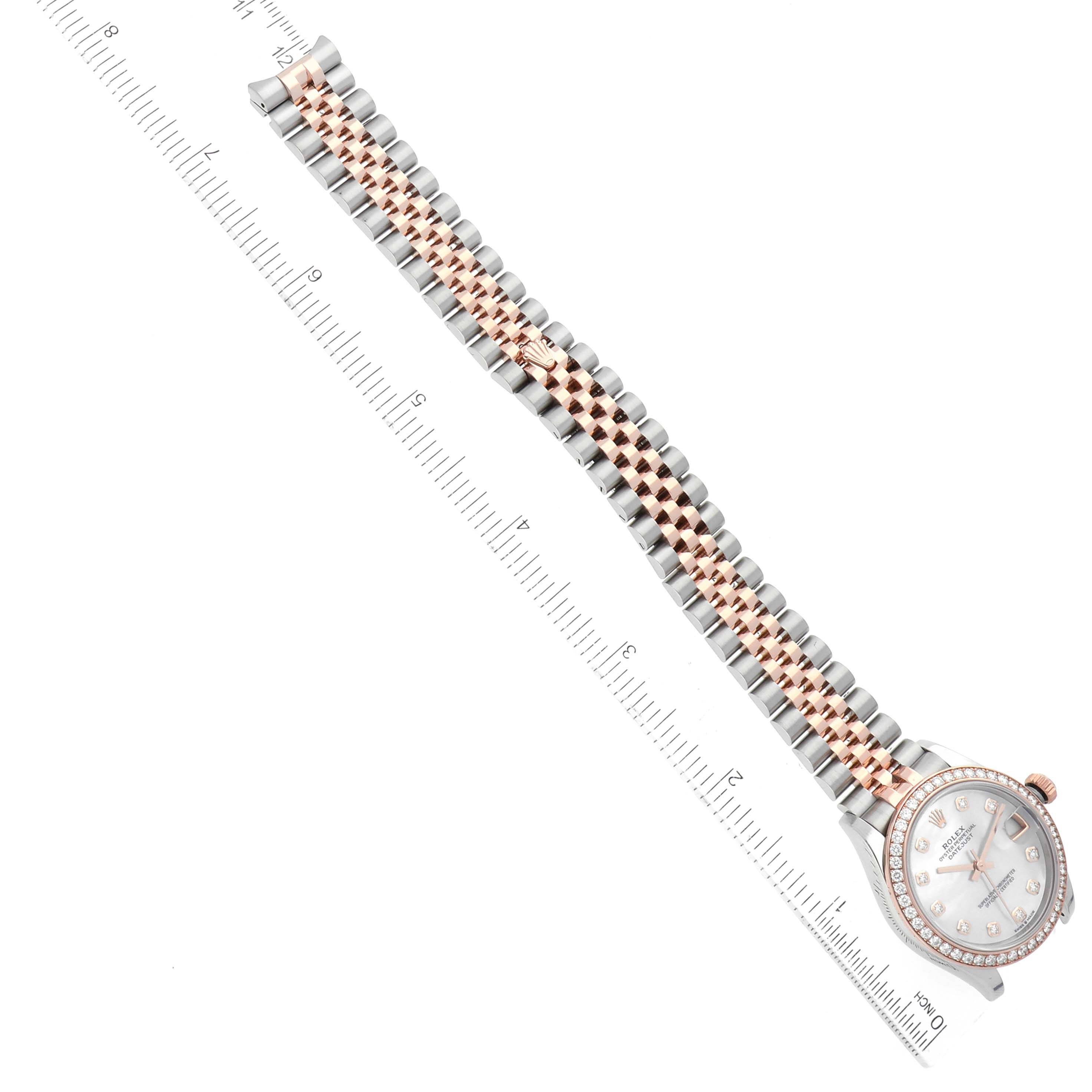 The image shows a Rolex Mid-Size 278381 Women
s Steel and Gold (two tone) Mother of Pearl Dial 278381 Women
s Steel and Gold (two tone) Mother of Pearl Dial model watch laid flat with its face and bracelet visible, next to a ruler for scale.