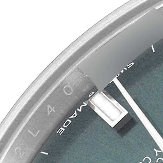 This close-up of the Rolex Mid-Size 278274 Women's Stainless Steel Green Dial 278274 Women's Stainless Steel Green Dial watch shows part of the dial, including the edge, indices, and partial text.
