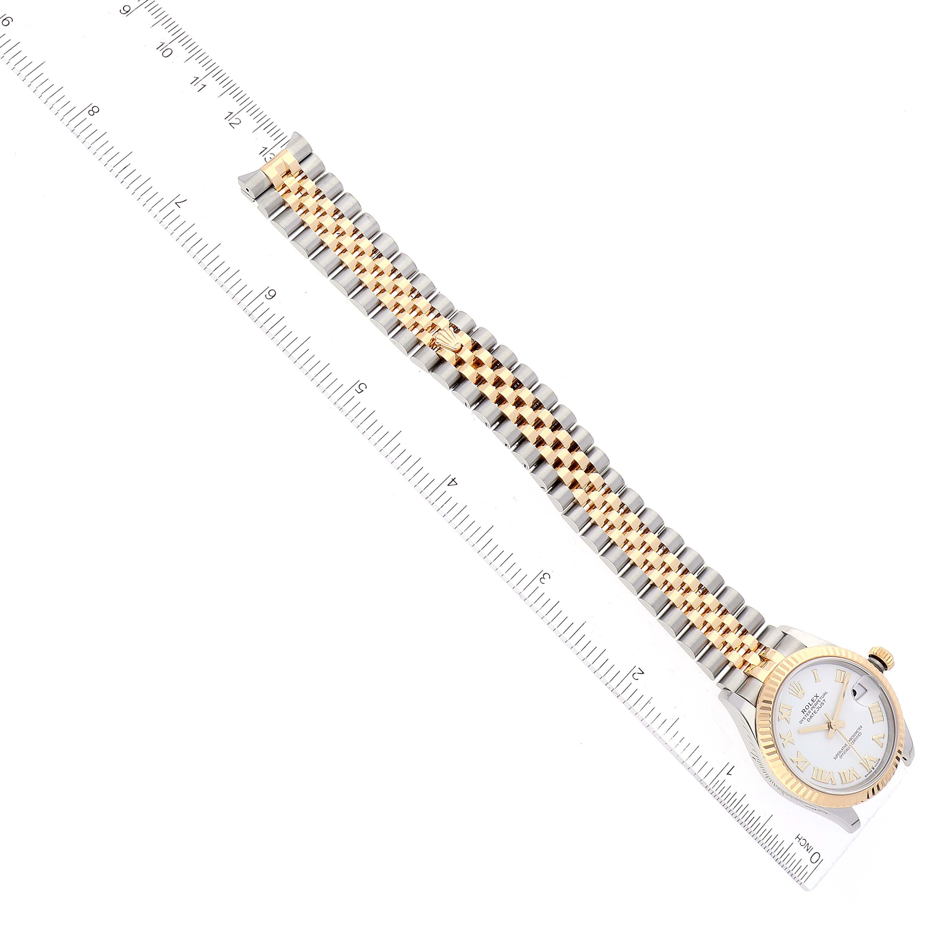 This image shows a Mid-Size Rolex watch laid flat with a ruler beside it for scale, capturing the watch face, bezel, and two-tone bracelet.