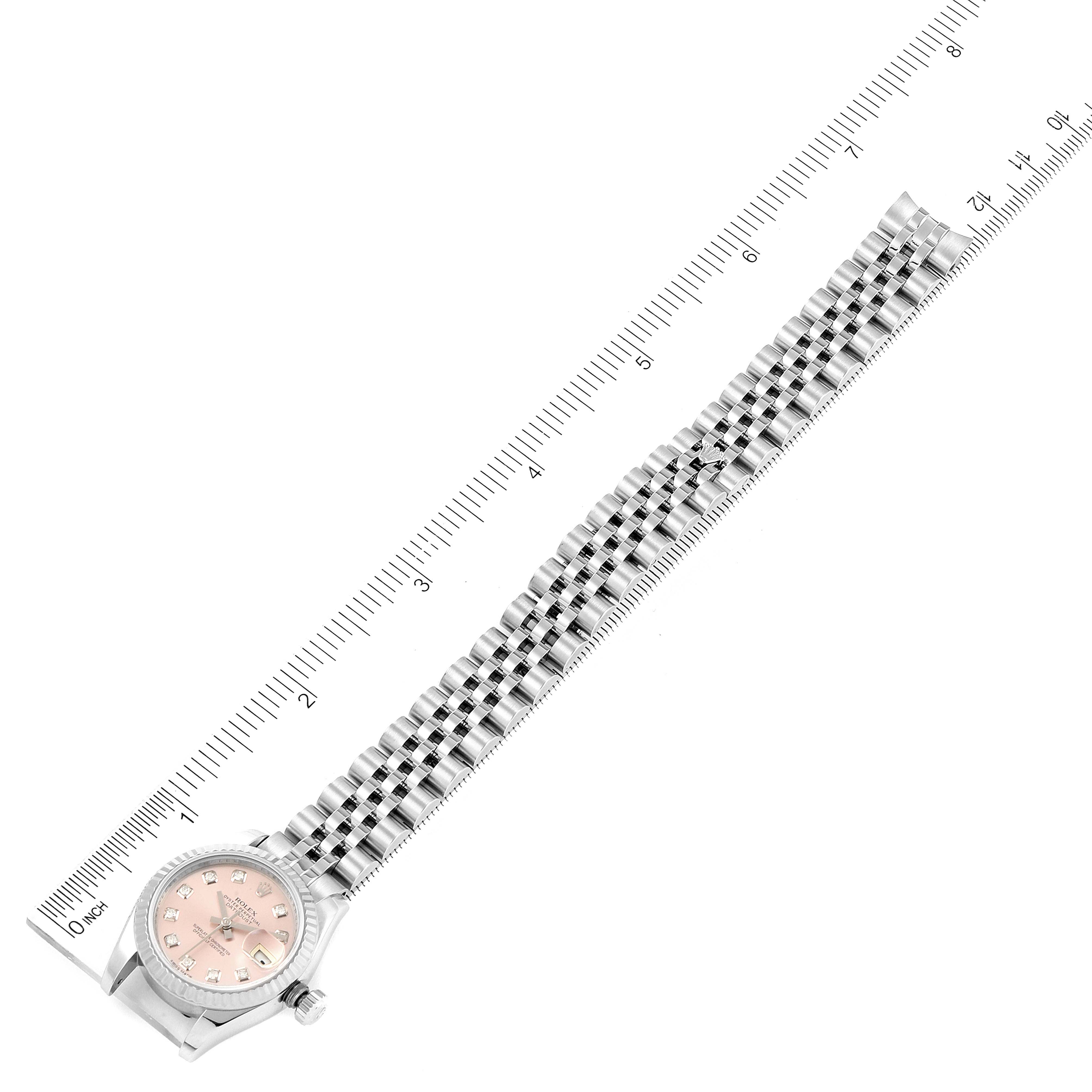 This top-view image shows a Rolex Datejust 179174 Women's Stainless Steel Pink Dial 179174 Women's Stainless Steel Pink Dial watch, highlighting its bracelet with a ruler next to it for measurement.