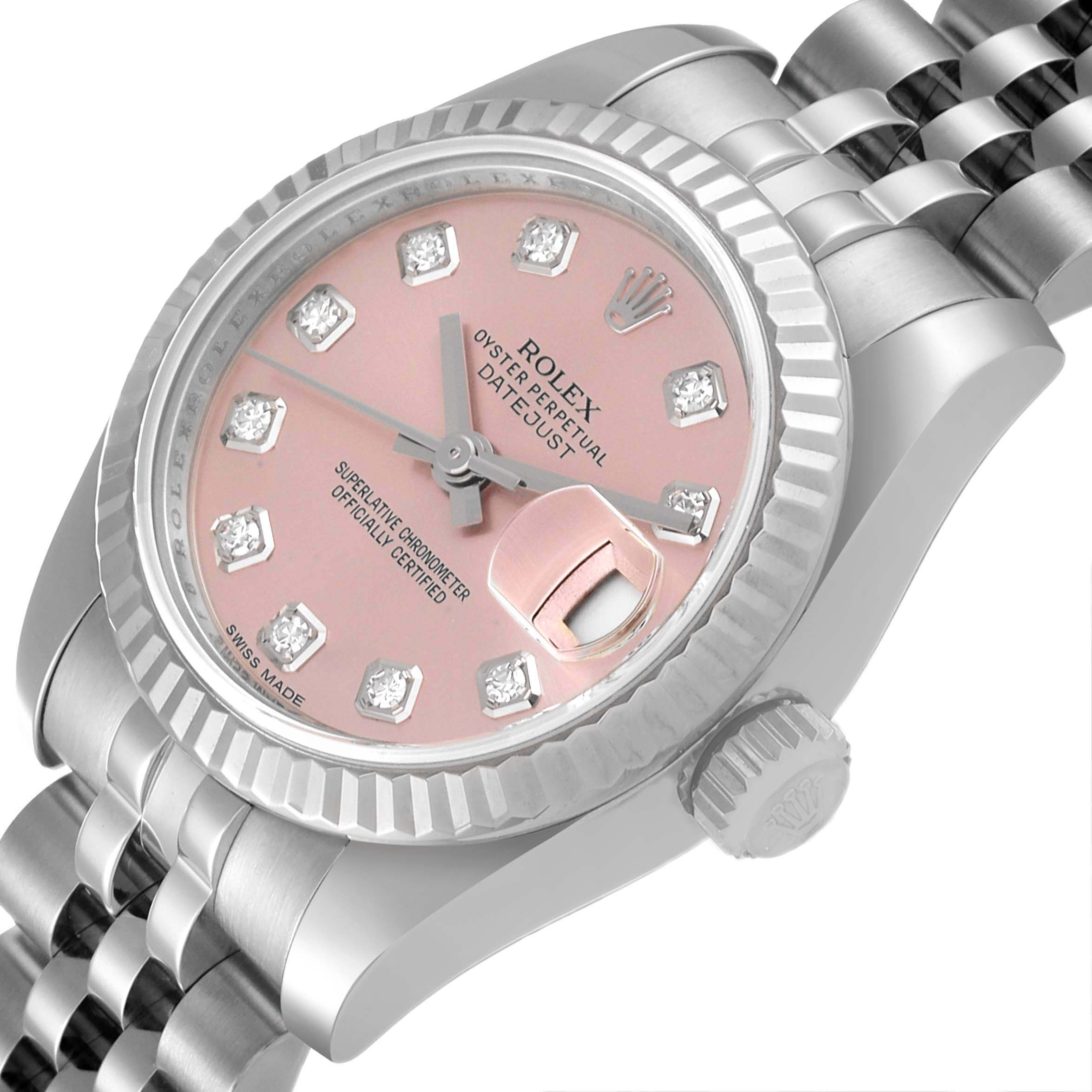 The image shows a close-up of the Rolex Datejust 179174 Women's Stainless Steel Pink Dial 179174 Women's Stainless Steel Pink Dial watch, highlighting its pink dial, fluted bezel, and part of the Jubilee bracelet.