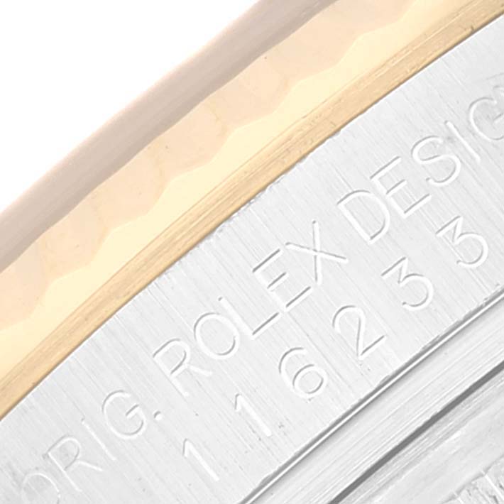 This is a close-up of the side engraving on a Rolex Datejust 116233 Men's Steel and Gold (two tone) Blue Dial 116233 Men's Steel and Gold (two tone) Blue Dial watch showing the model number and design information.