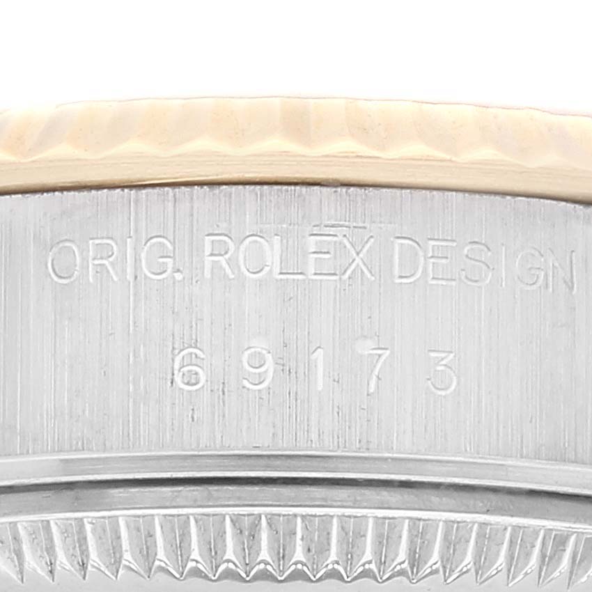 The image shows a close-up side view of a Rolex Datejust 69173 Women's Steel and Gold (two tone) Mother of Pearl Dial 69173 Women's Steel and Gold (two tone) Mother of Pearl Dial watch, focusing on the bezel and engravings.