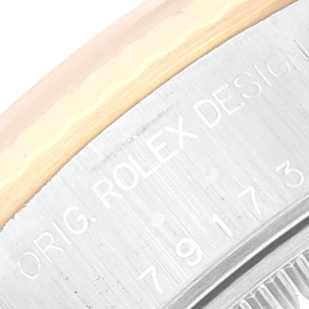 The image shows a close-up angle of the Rolex Datejust 79173 Women's Steel and Gold (two tone) Silver Dial 79173 Women's Steel and Gold (two tone) Silver Dial watch case, focusing on engravings and part of the bezel.