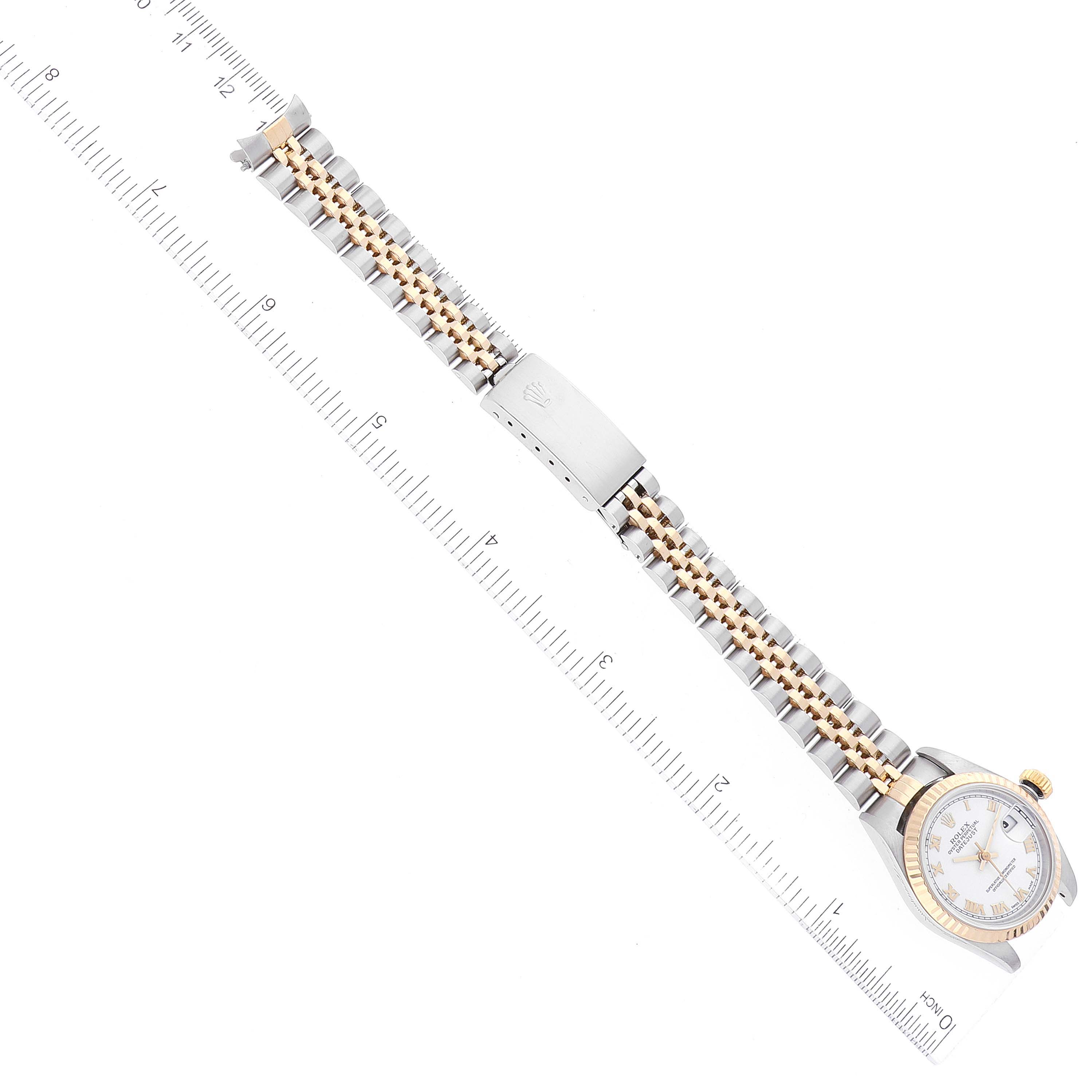 The image shows a Rolex Datejust 79173 Women's Steel and Gold (two tone) White Dial 79173 Women's Steel and Gold (two tone) White Dial watch laid flat with the entire watchband, clasp, and face visible next to a measuring ruler.