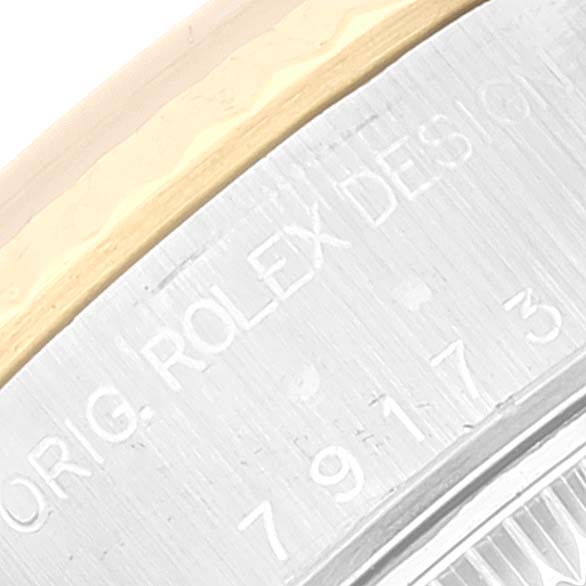 The image shows a close-up of the Rolex Datejust 79173 Women's Steel and Gold (two tone) White Dial 79173 Women's Steel and Gold (two tone) White Dial model's bezel and part of the case with “ORIG. ROLEX DESIGN” engraved.