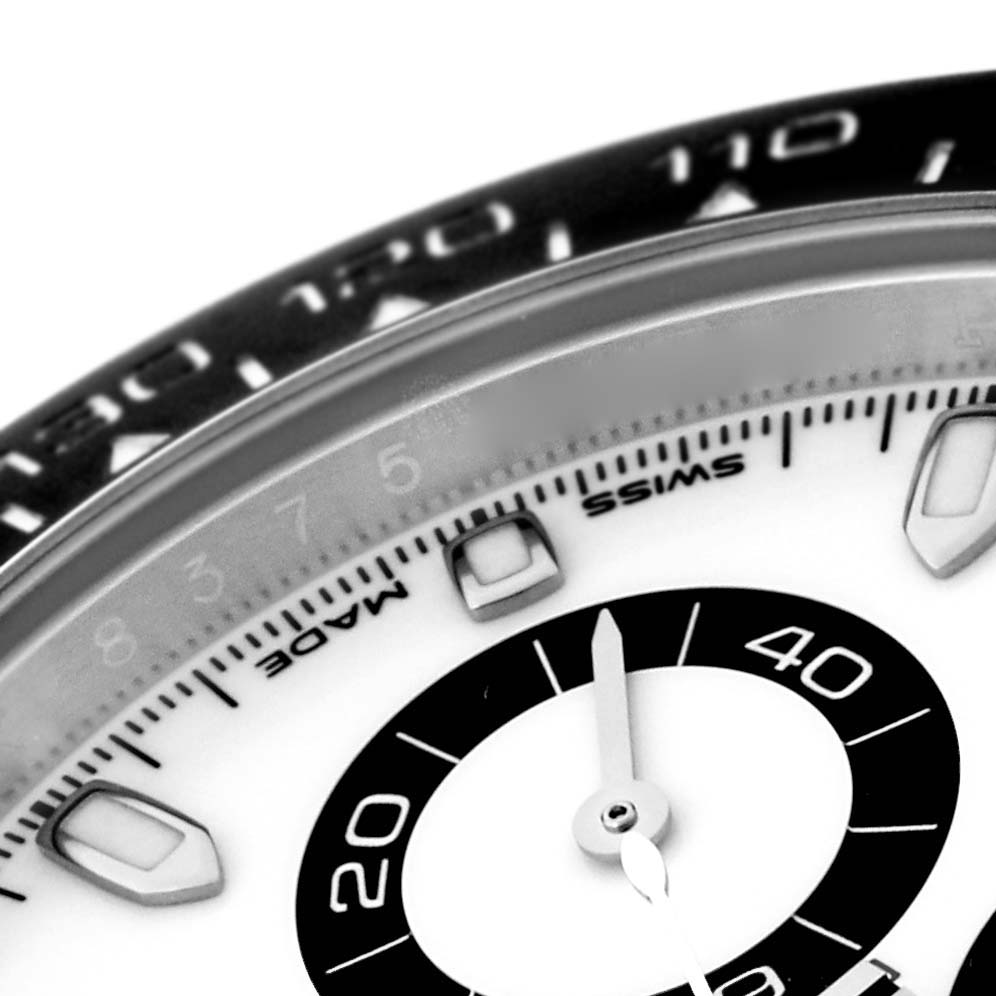 This close-up of the Rolex Daytona 116500 Men's Stainless Steel White Dial 116500 Men's Stainless Steel White Dial watch shows part of the dial, hands, and a segment of the bezel at an angled view.