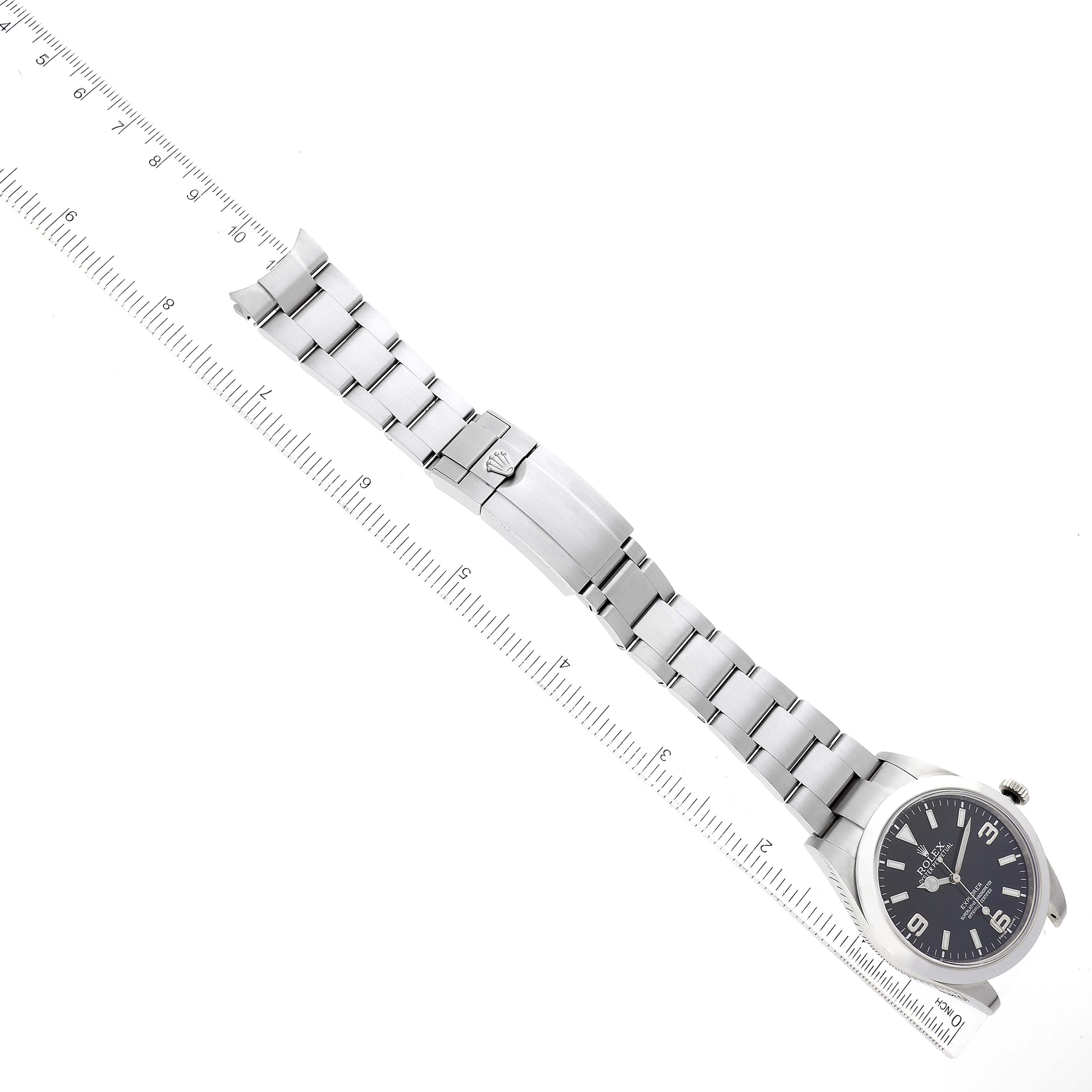 This image shows a top-down view of a Rolex Explorer 214270 Men
s Stainless Steel Black Dial 214270 Men
s Stainless Steel Black Dial watch laid flat next to a ruler, displaying the bracelet and clasp.