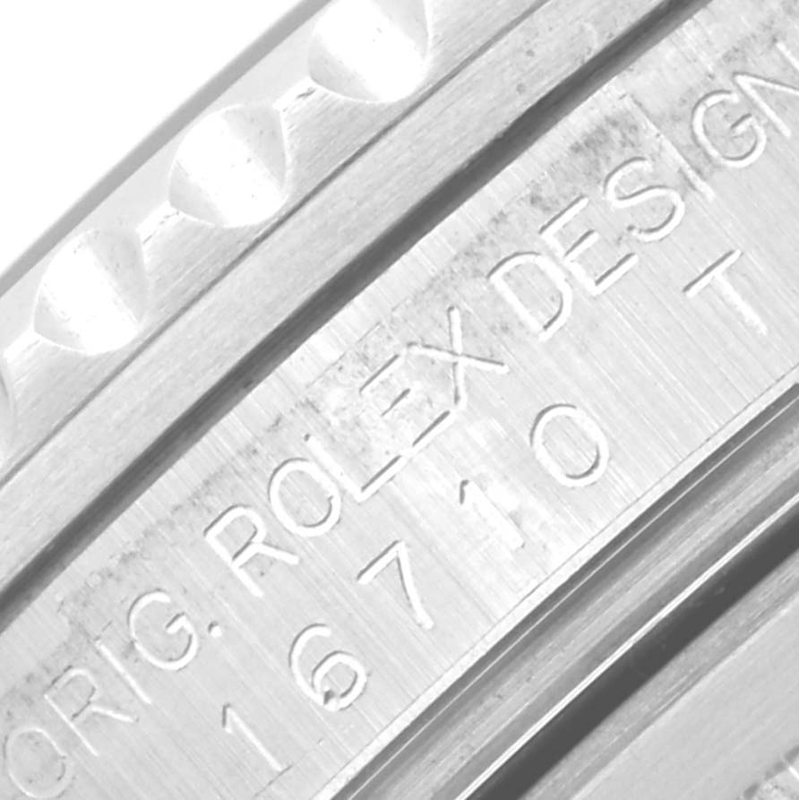 The image shows a close-up of the engraving on the side of the bezel and case of a Rolex GMT-Master 16710 Men's Stainless Steel Black Dial 16710 Men's Stainless Steel Black Dial.