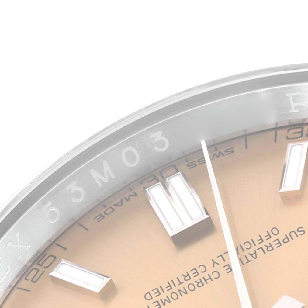 This image shows a close-up angle of the dial and part of the bezel of a Rolex Oyster Perpetual 116000 Men's Stainless Steel Champagne Dial 116000 Men's Stainless Steel Champagne Dial watch.