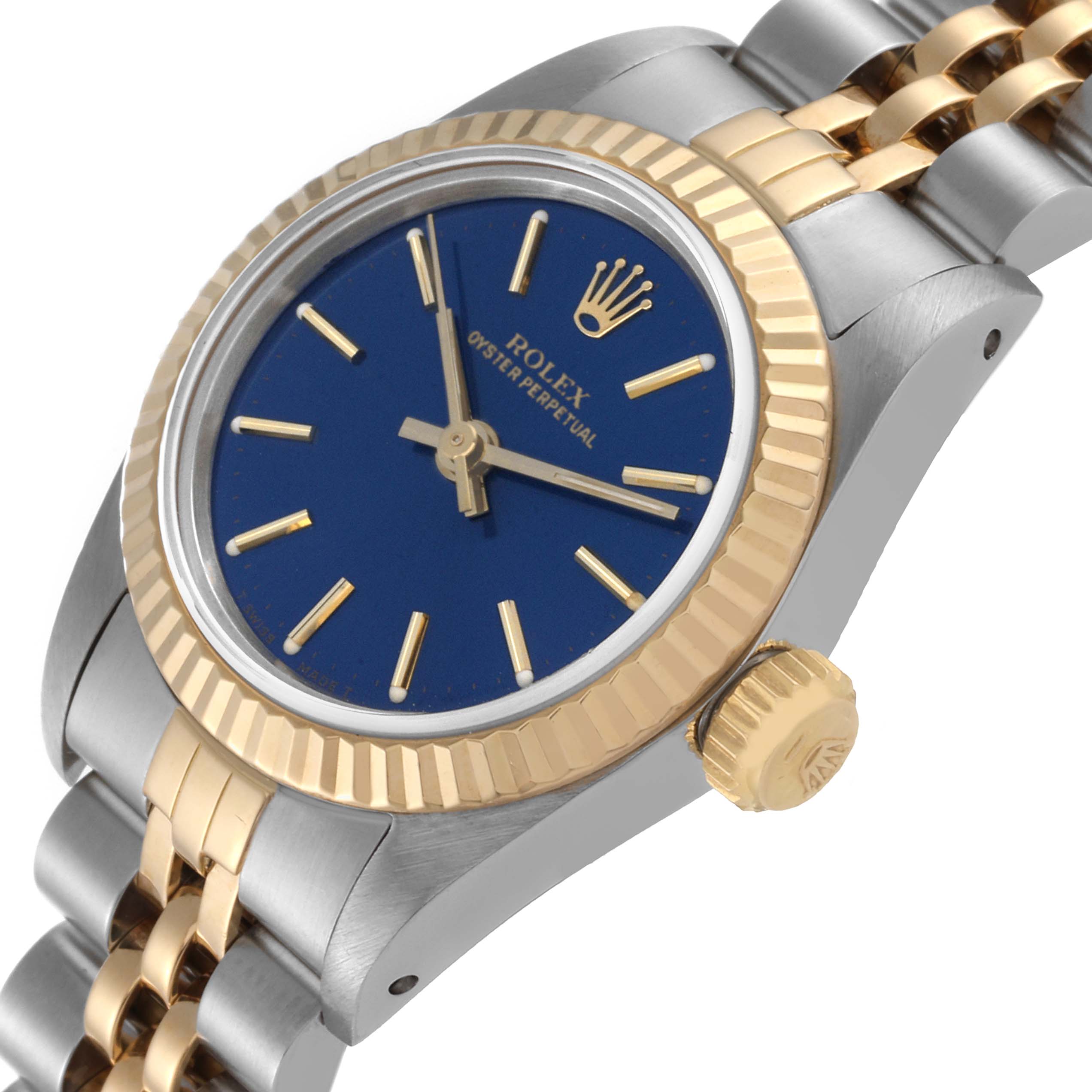 This image shows a Rolex Oyster Perpetual 67193 Women's Steel and Gold (two tone) Blue Dial 67193 Women's Steel and Gold (two tone) Blue Dial watch from a slight angle, highlighting its blue dial, gold fluted bezel, and two-tone bracelet.