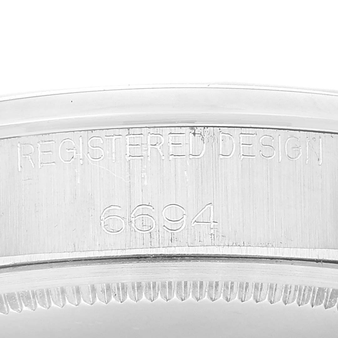 The image shows a close-up of the side of the Rolex Vintage Collection 6694 Men's Stainless Steel Silver Dial 6694 Men's Stainless Steel Silver Dial model, highlighting the engraved design number 6694.