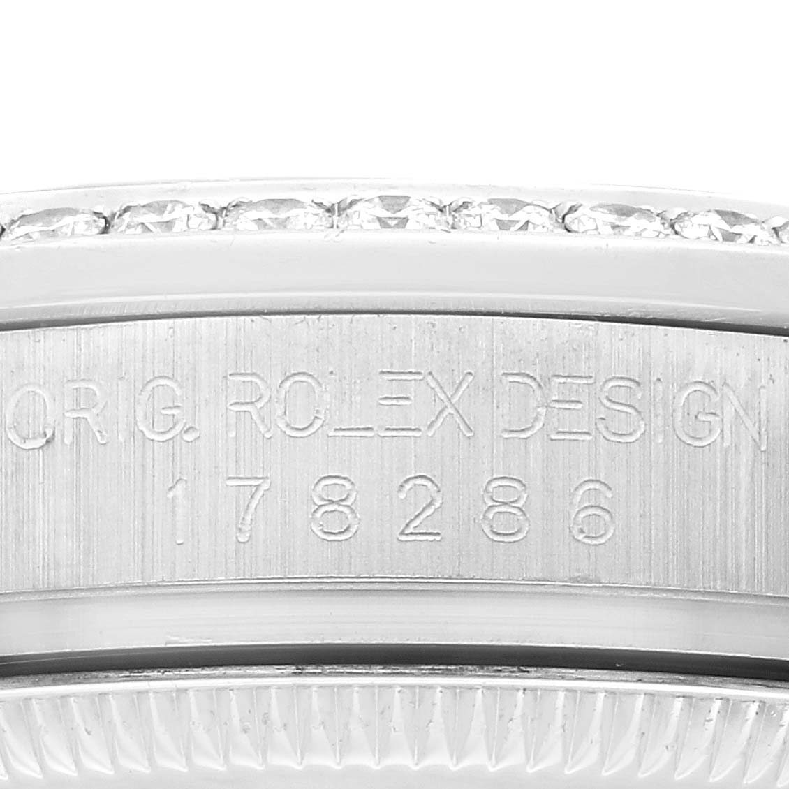 This image shows a close-up of the engraved side of the bezel on a Rolex President 178286 Women's Platinum Blue Dial 178286 Women's Platinum Blue Dial model watch, featuring the serial number.