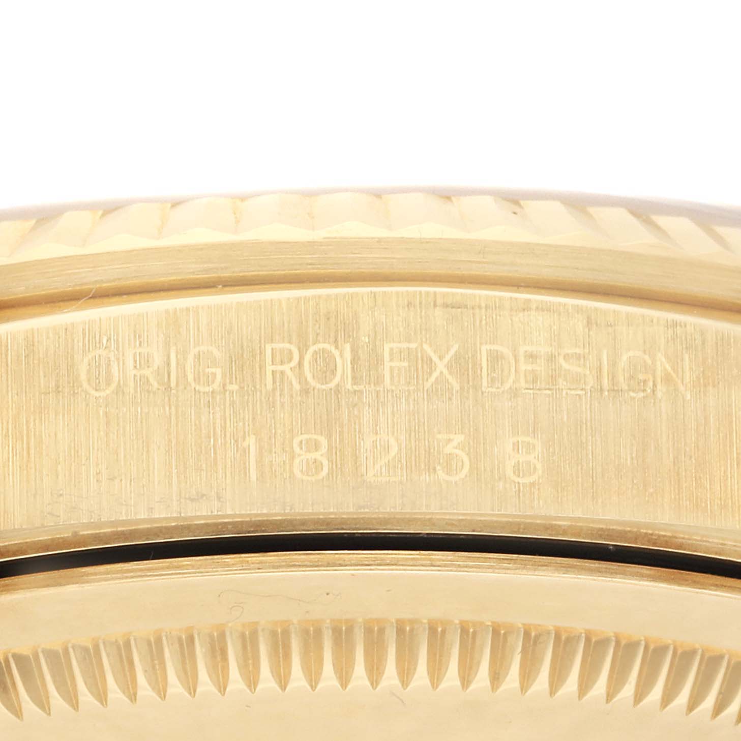 The image shows a close-up side view of the bezel and the case of a Rolex President 18238 Men
s Yellow Gold Champagne Dial 18238 Men
s Yellow Gold Champagne Dial model with the engraving "ORIG. ROLEX DESIGN 18238".