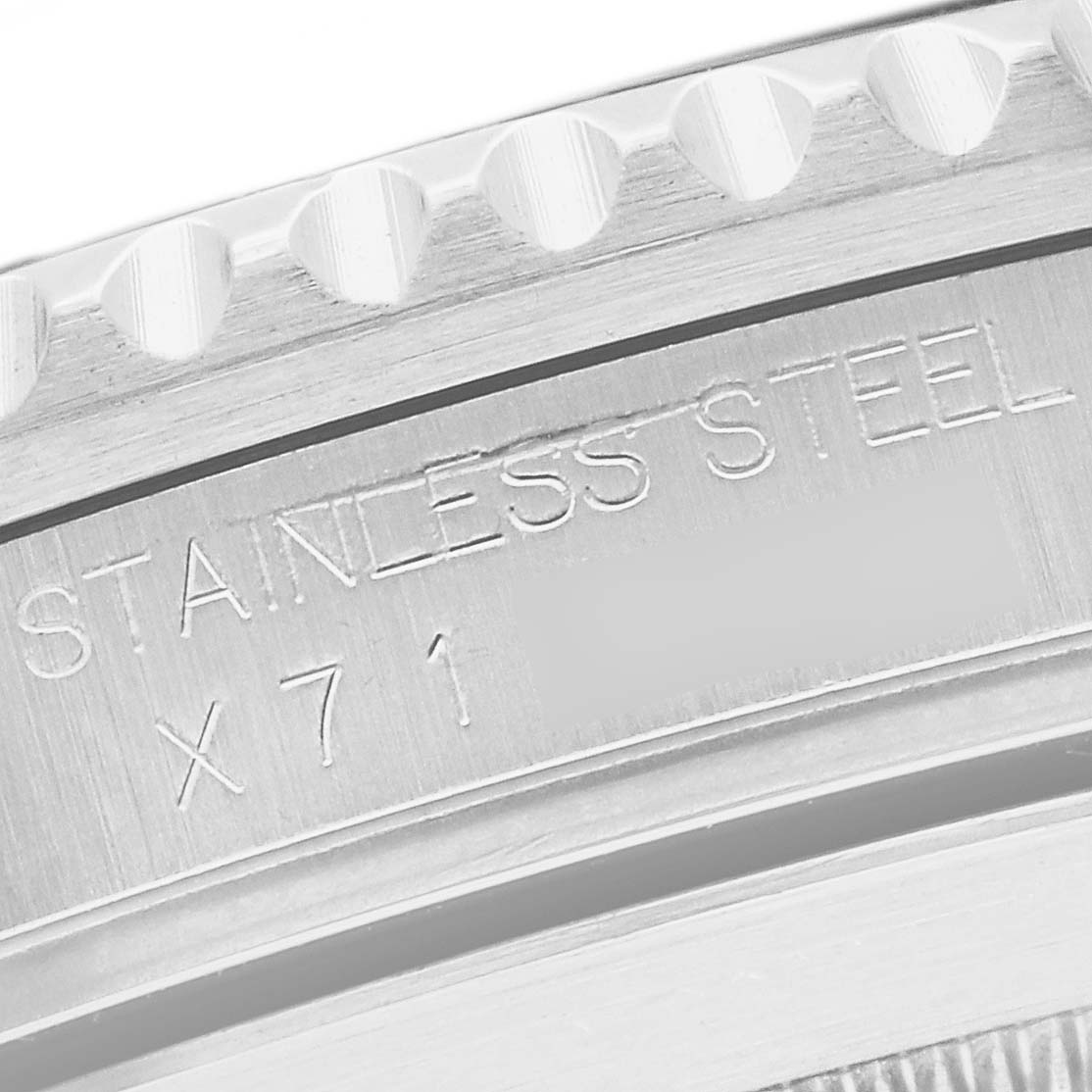 The image shows a close-up of the case back edge of a Rolex Submariner 16610 Men
s Stainless Steel Black Dial 16610 Men
s Stainless Steel Black Dial, focusing on the "STAINLESS STEEL" engraving.